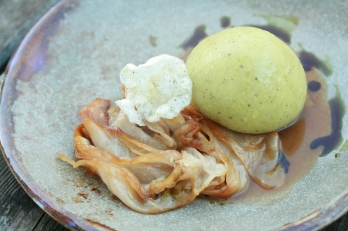 Ein mit Mangalitzabrüstl gefüllter Germknödel auf Fischbacher Grubenkraut