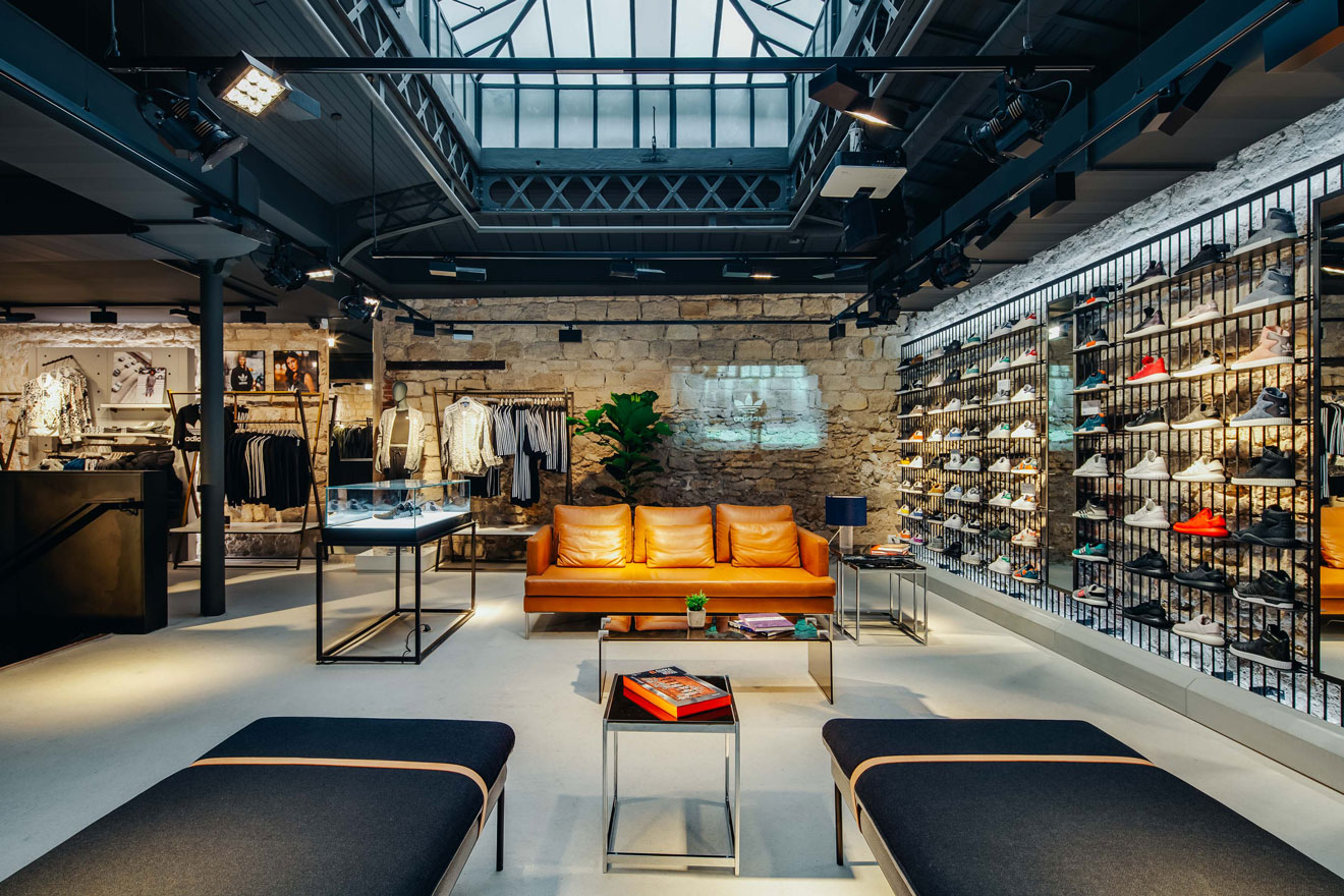 La Boutique phare de "Adidas Originals" à Paris. L’espace entre les produits est agencé par la mise en place d'un espace confortable qui permet aux clients de se sentir bien accueillis.