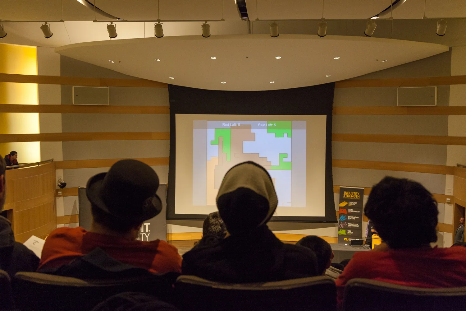 A student presents a game he developed at Neumont University's Capstone Project Invitational.
