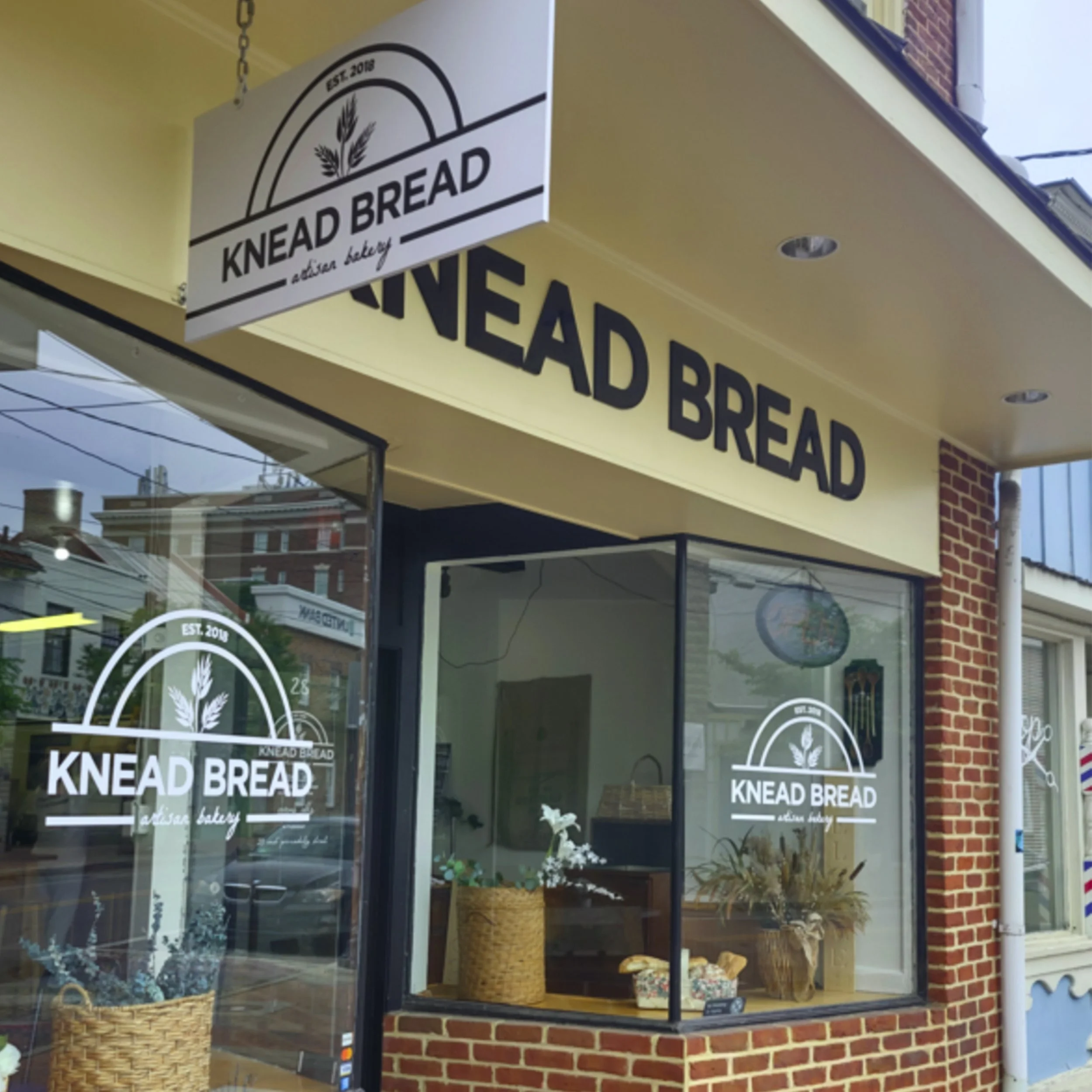 brick store front with knead bread logo on window