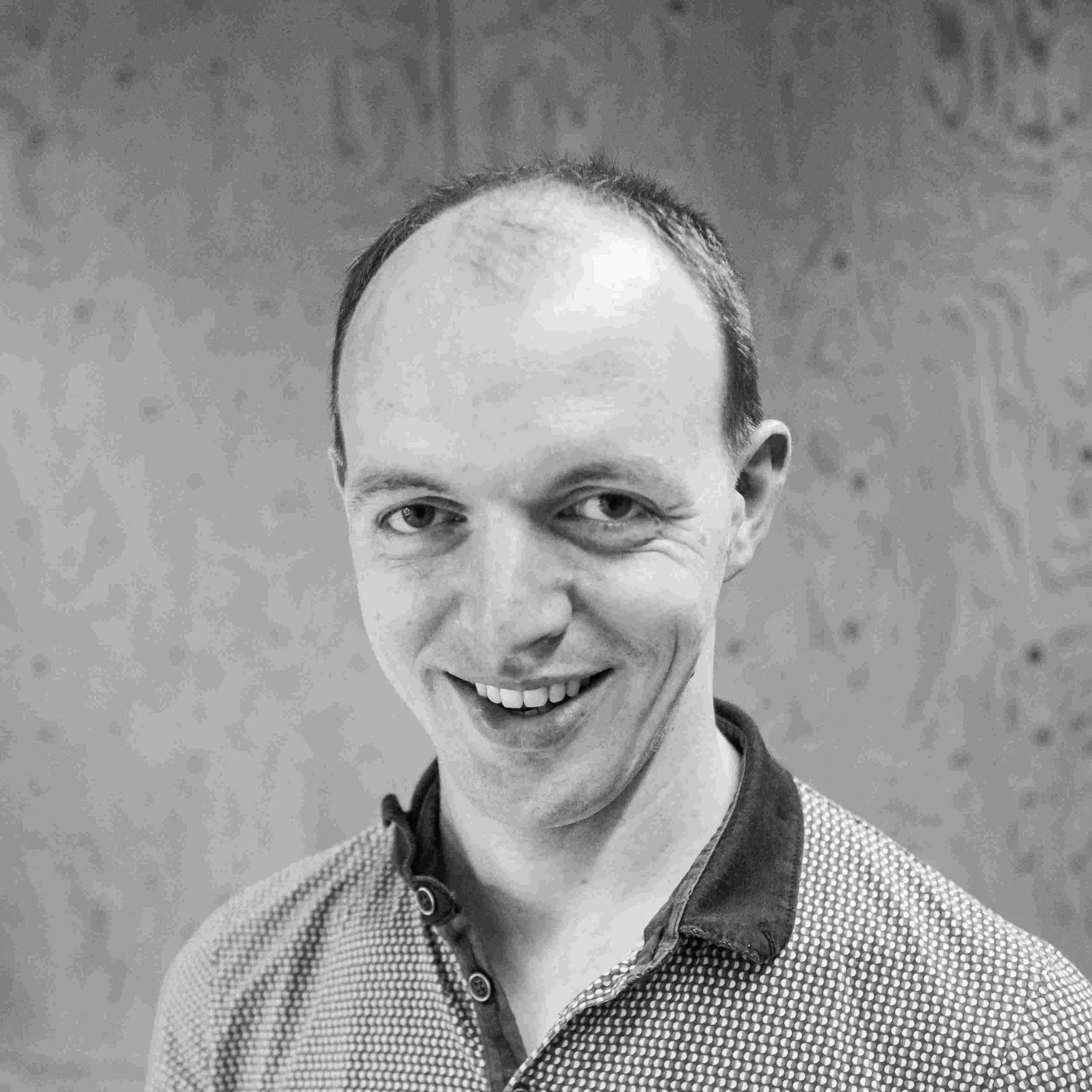 head and shoulders image of a man in an open neck polo shirt