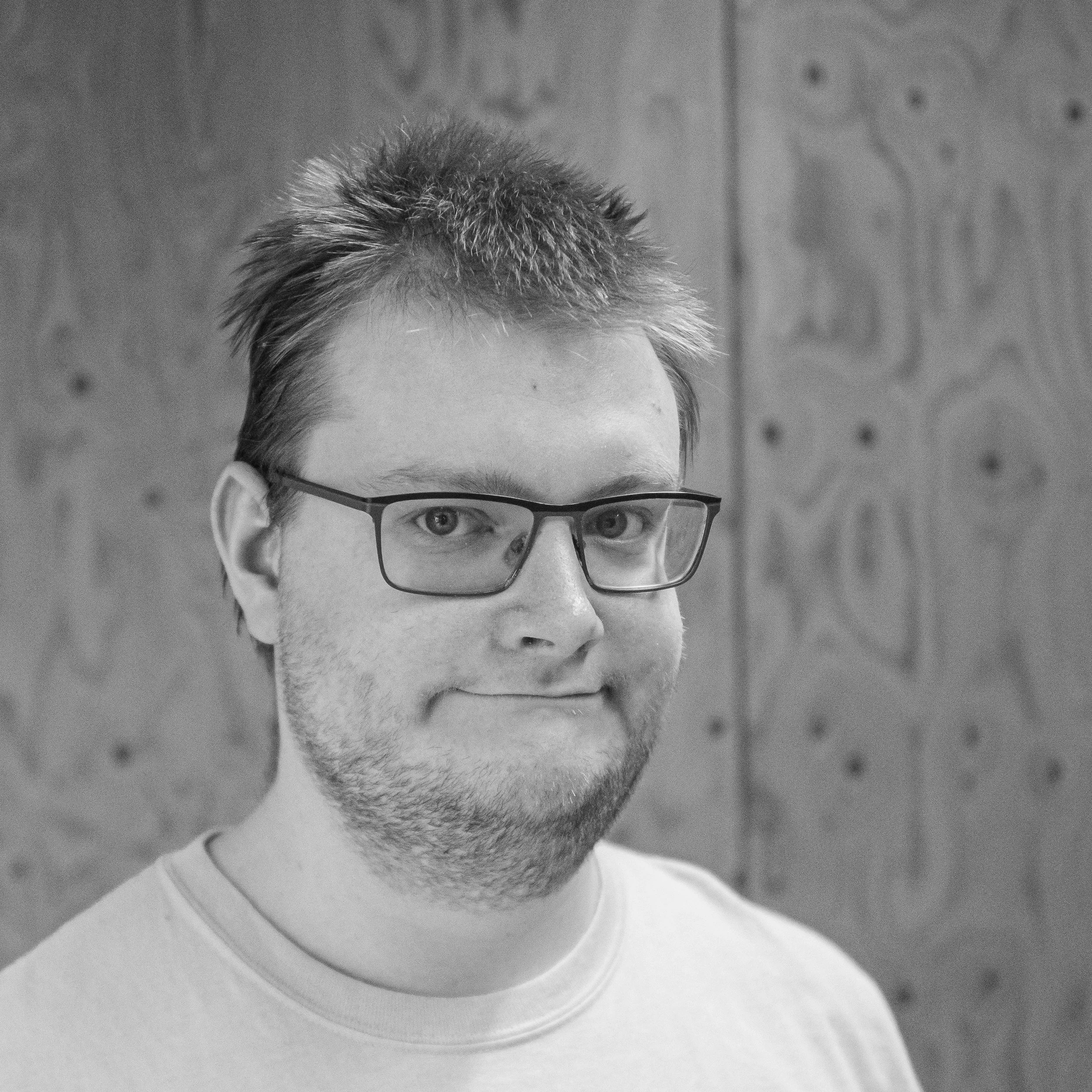 head and shoulders image of a man wearing glasses and a pale tee shirt