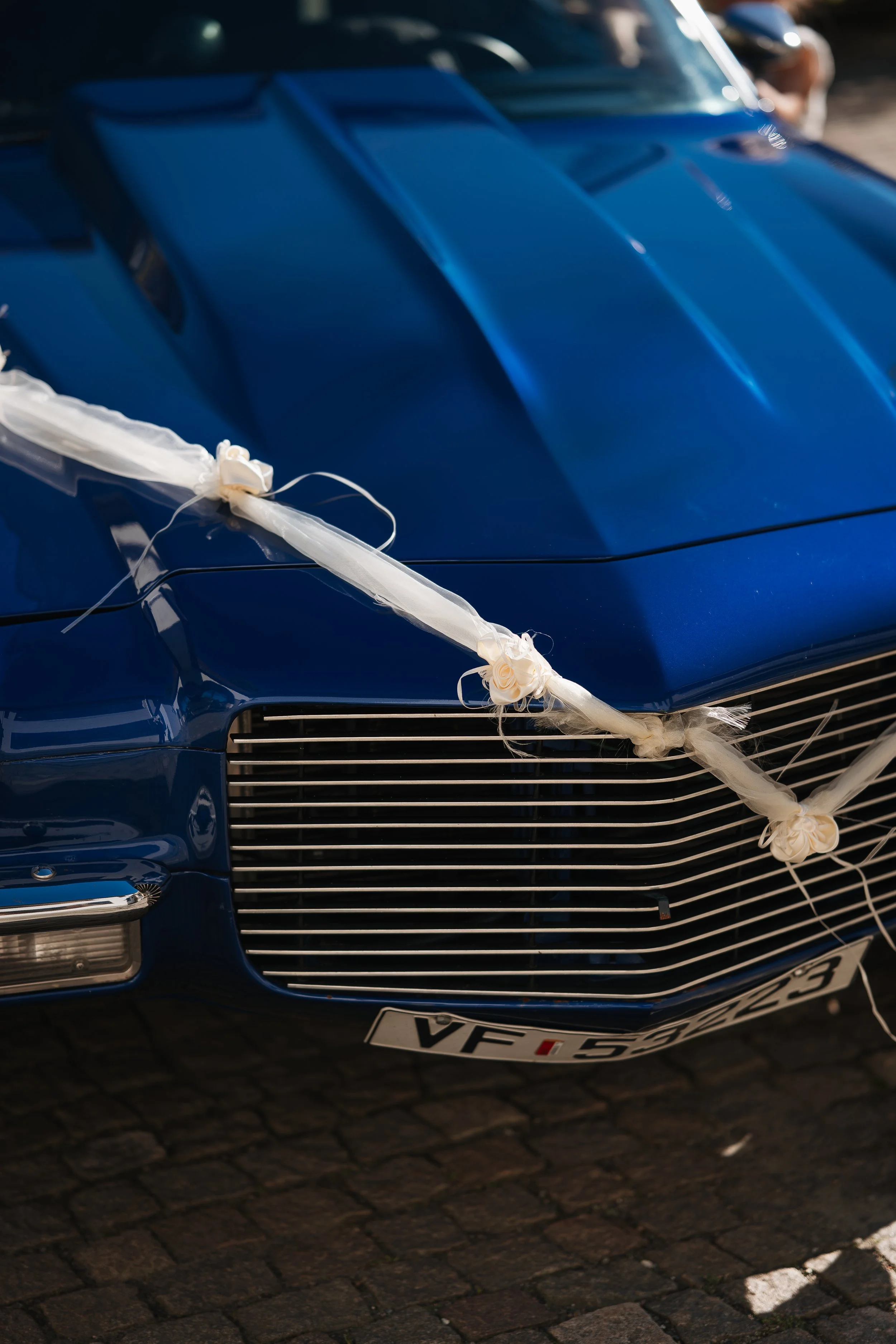 Sort K S B Mercedes-Benz åpenbart i en bryllupsdekorasjon på en gate, dekorert med hvit og kremfarget bånd og roser.