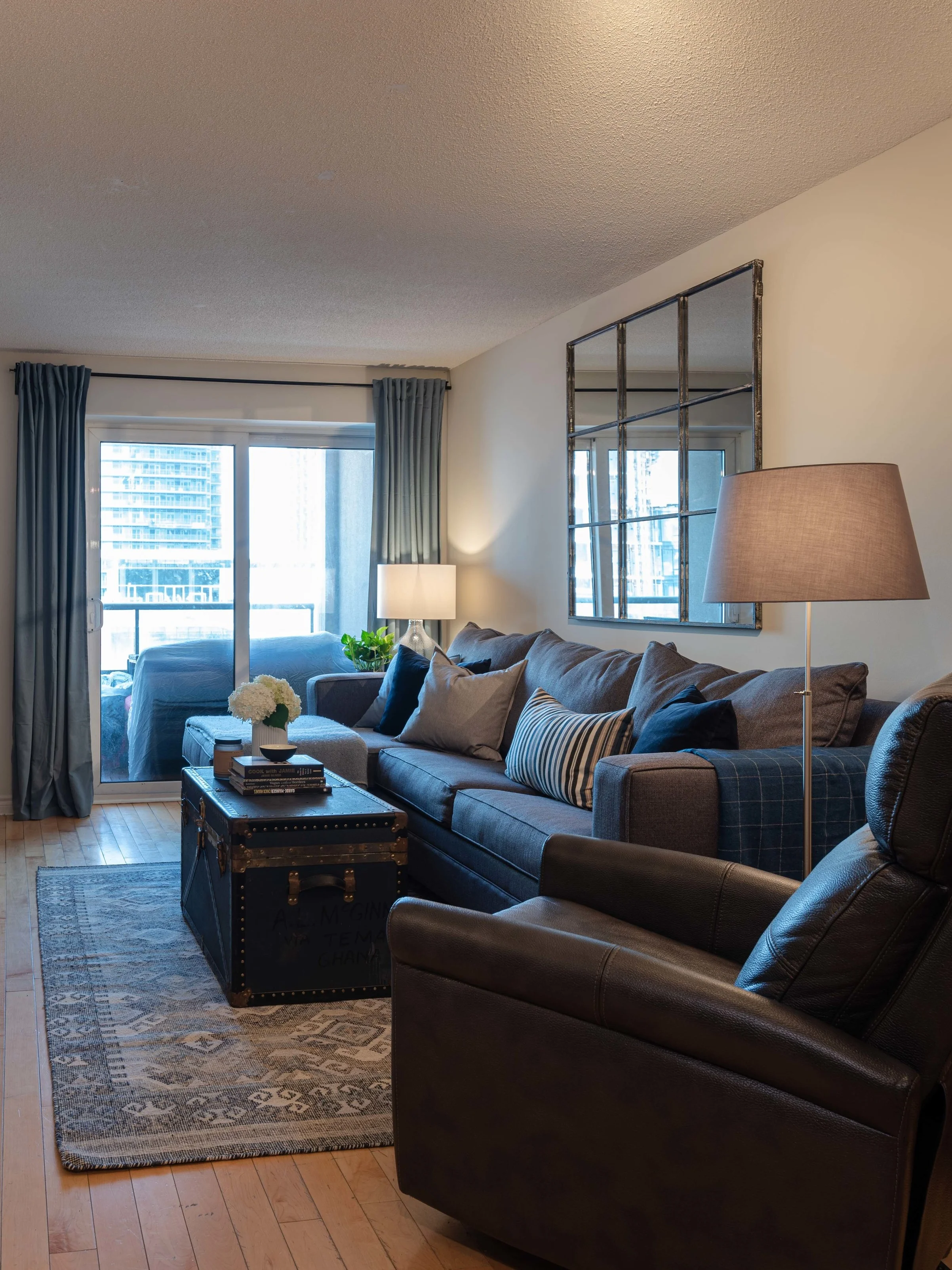 A large mirror acts like an additional window by reflecting light and a sleek recliner offers ultra-comfy additional seating. The new warm white wall colour is bright and airy.