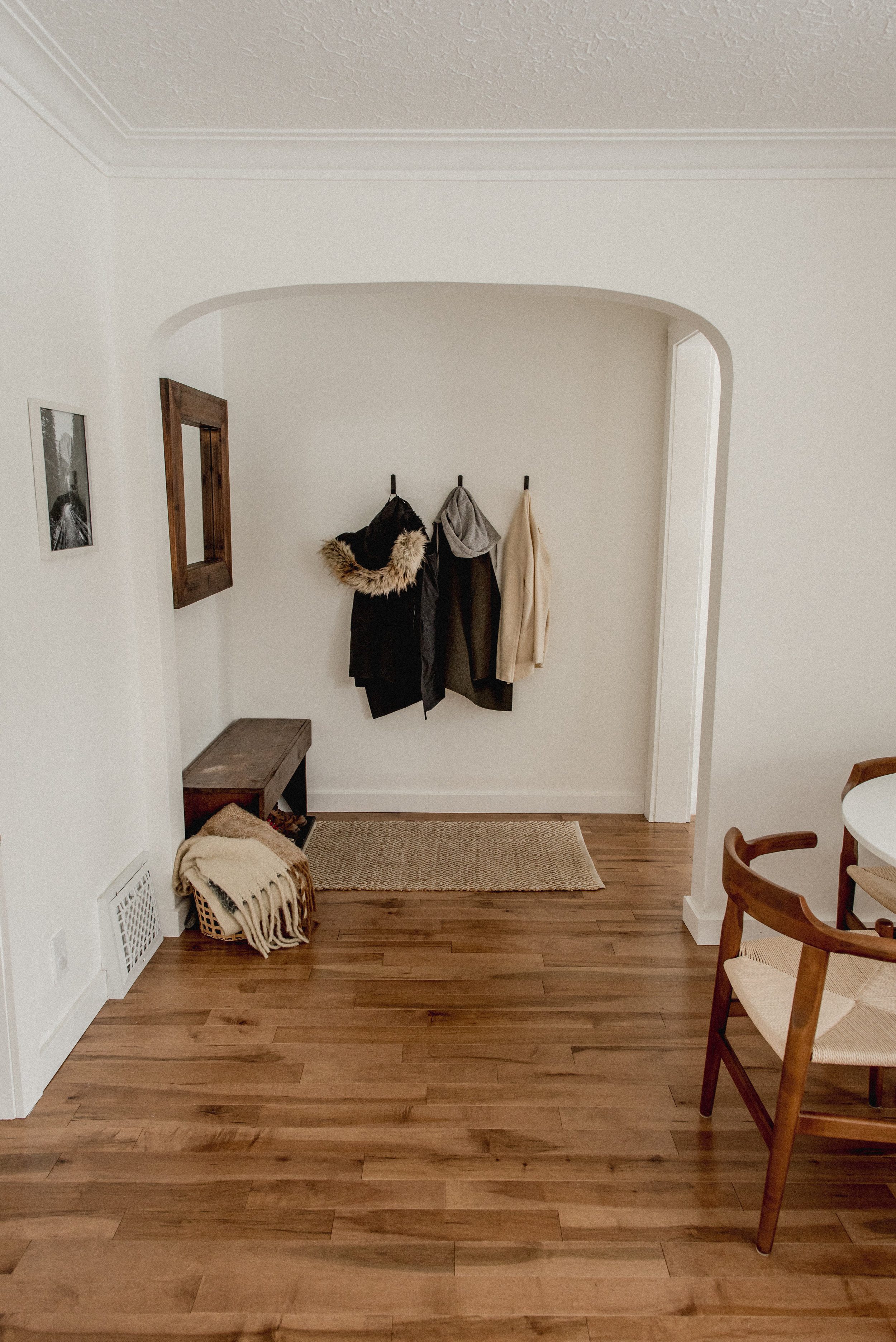 Simple and minimalist entrance way with bench and wall hooks