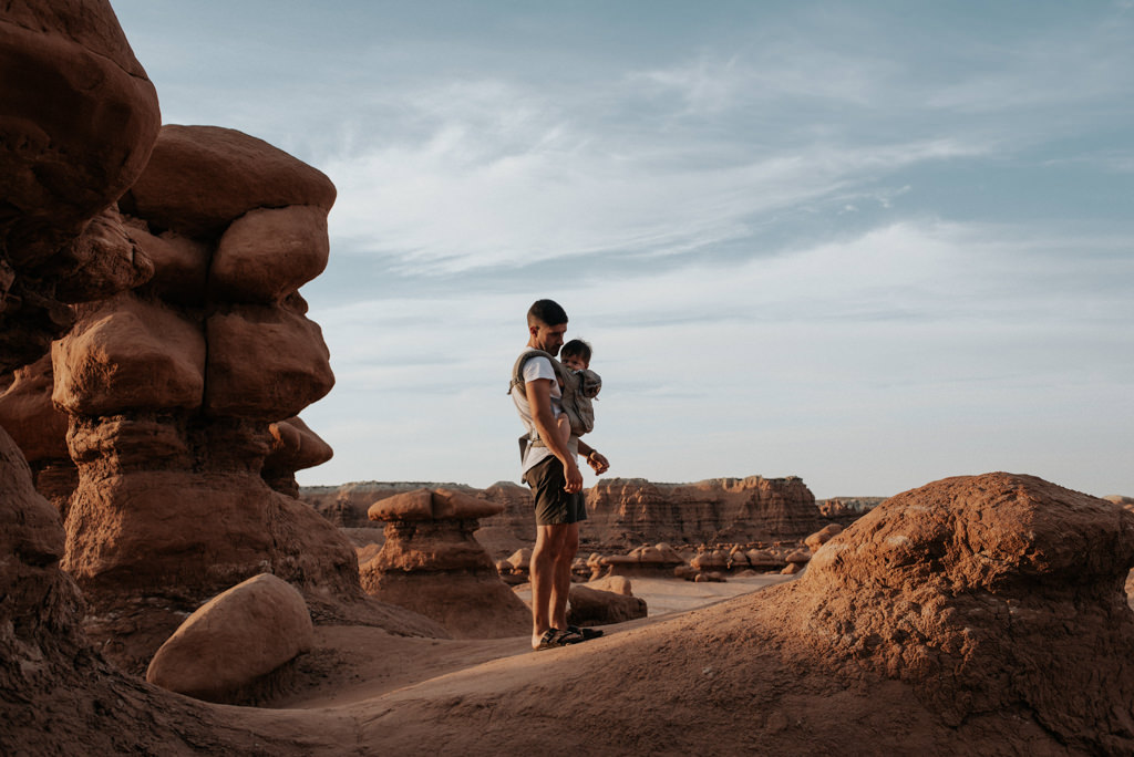 Father with infant son in carrier hiking at Goblin Valley State Park