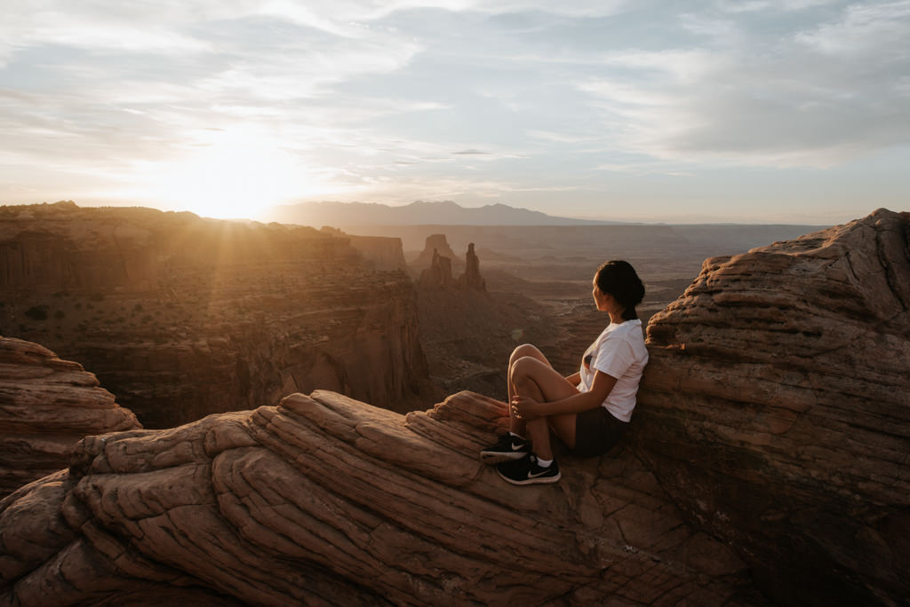 Woman watching sunrise at Mesa Arch in Canyonlands National Park