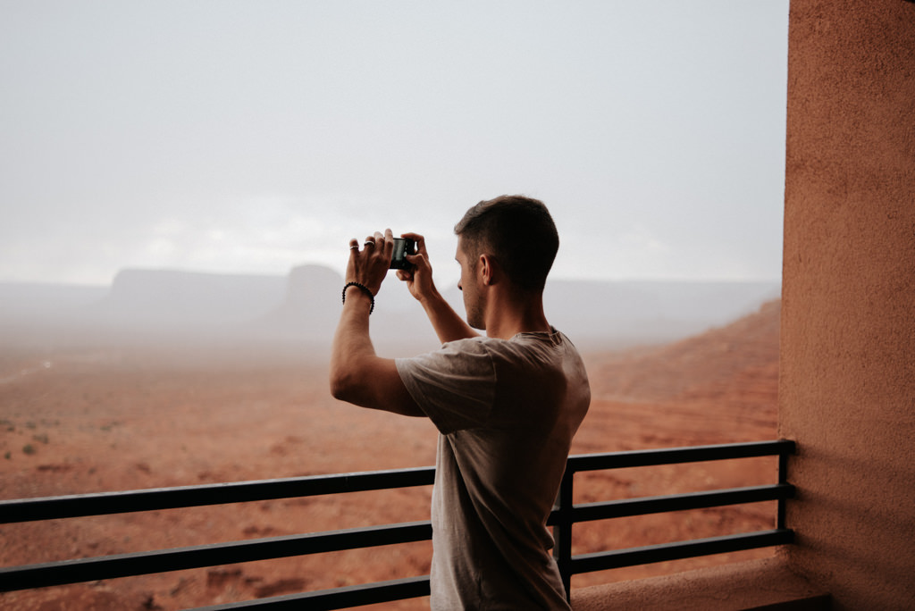 Man taking picture of Monument Valley from balcony of hotel room at the View Hotel