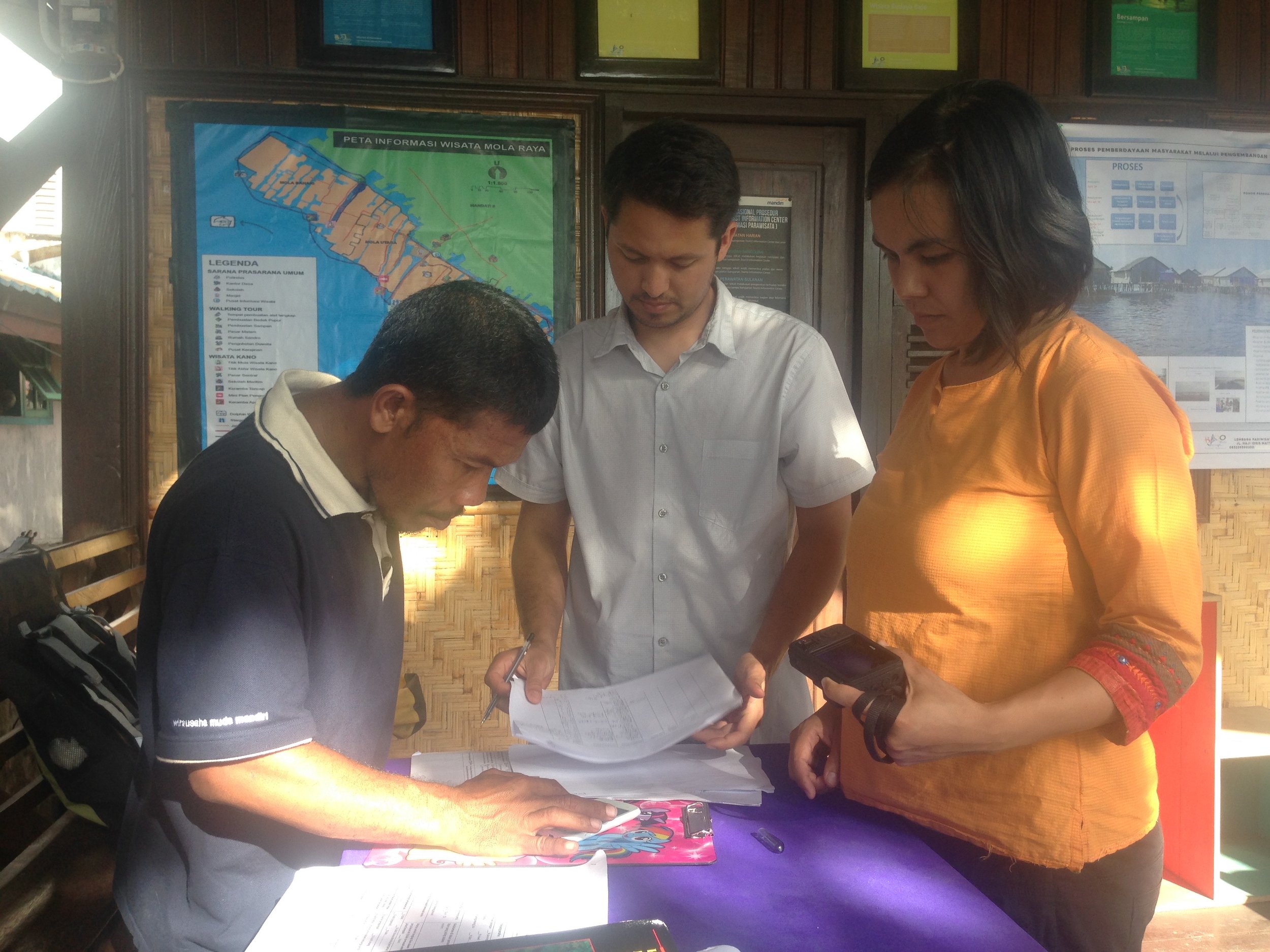 Melati, Paul, and Albar looking over catch data