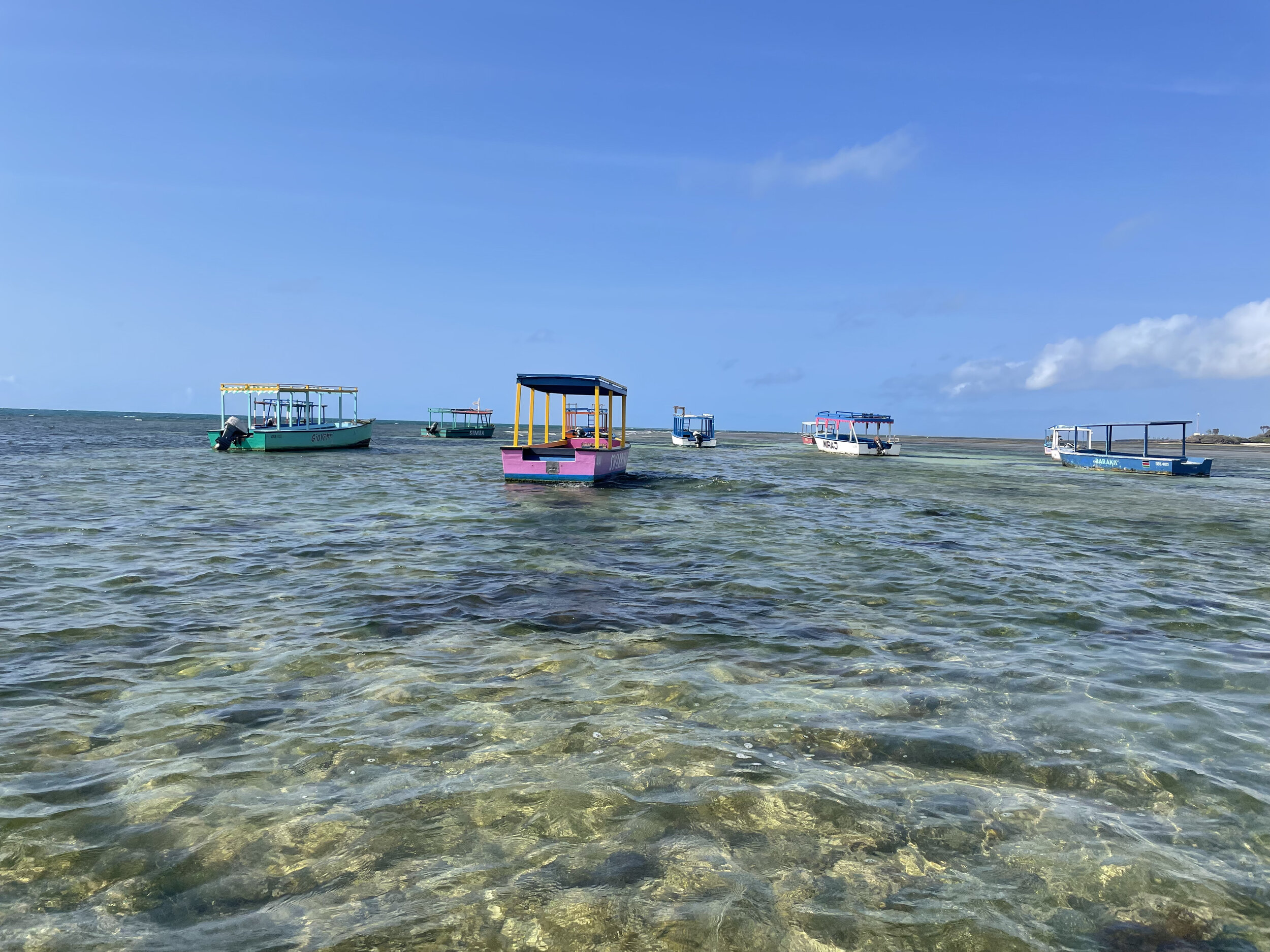 Dive boats float on a shallow reef in Watamu MPA, Kenya