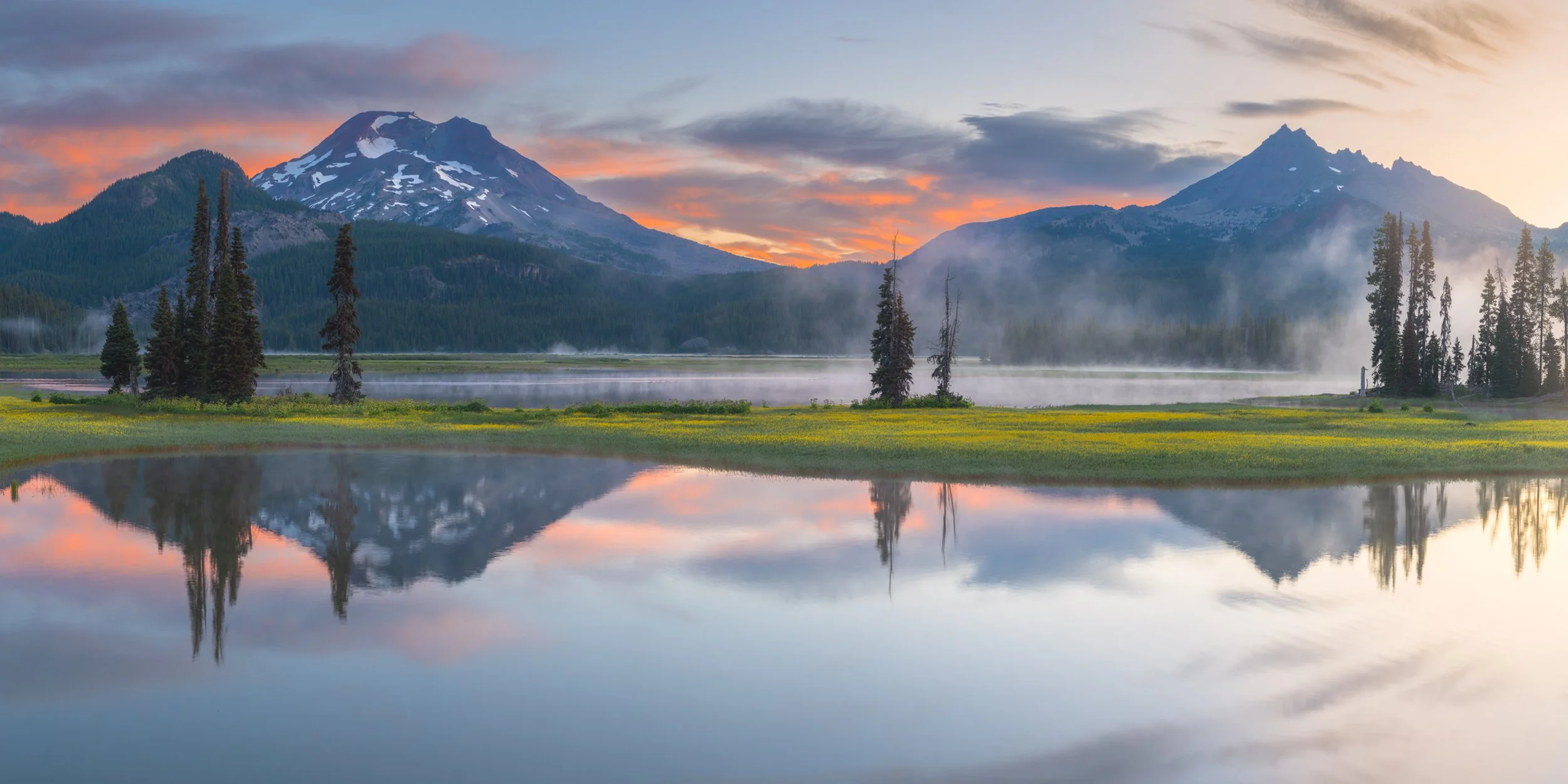 Large Panoramic Landscape Photography Wall Art: A calming sunrise over the still lake with the mountains in the background as mist fills the valley.