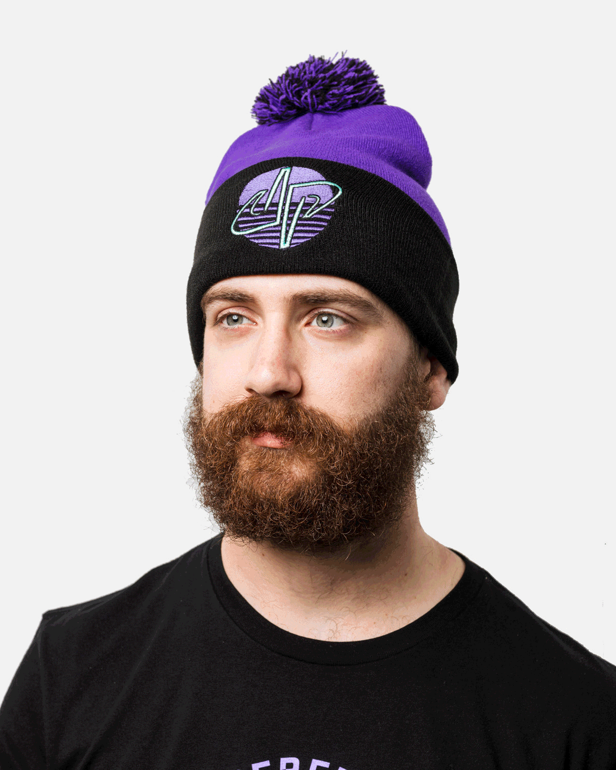 Man wearing a purple and black beanie with a logo, and a black T-shirt on a white background.