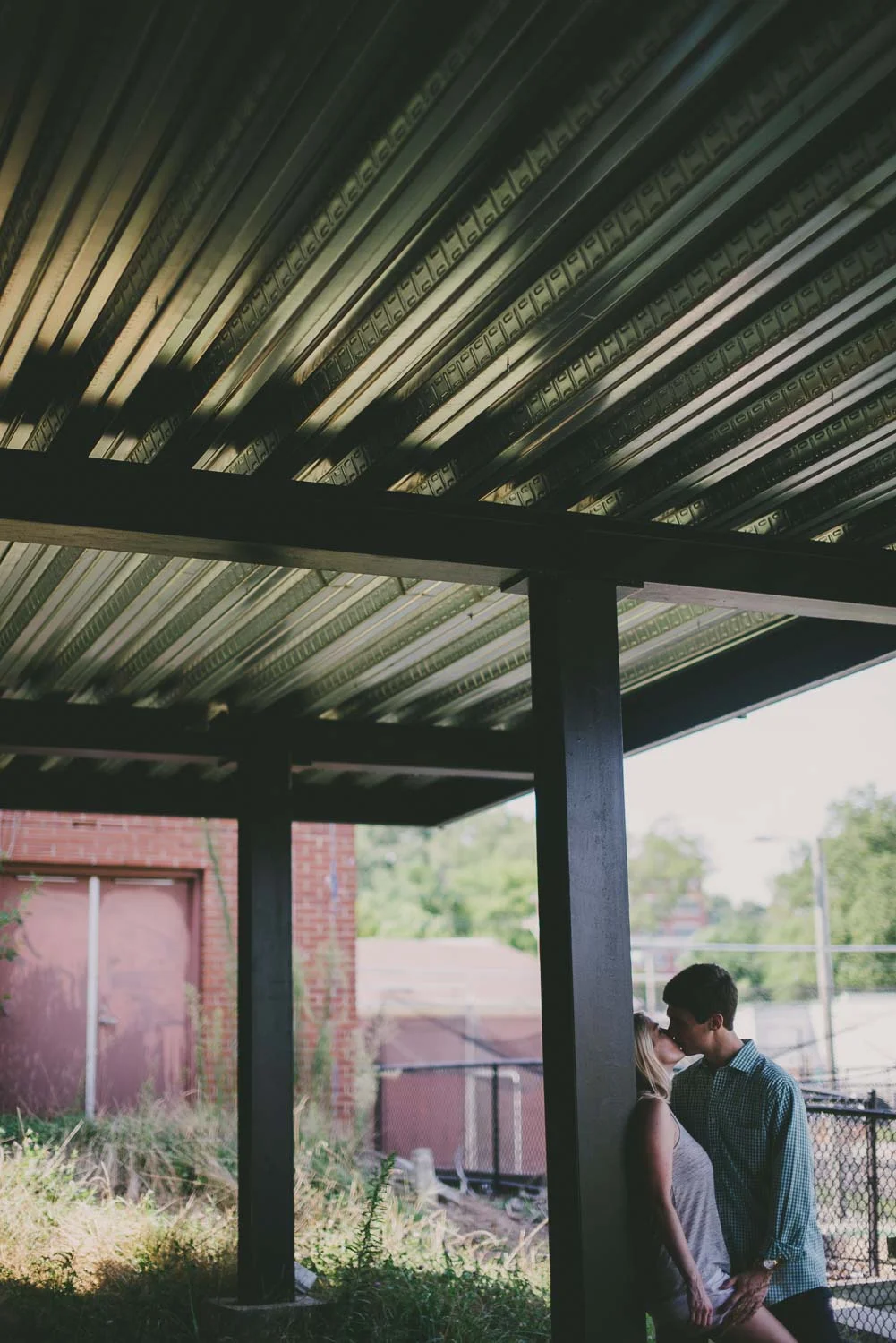 Couple sharing a kiss under the deck, Durham, NC