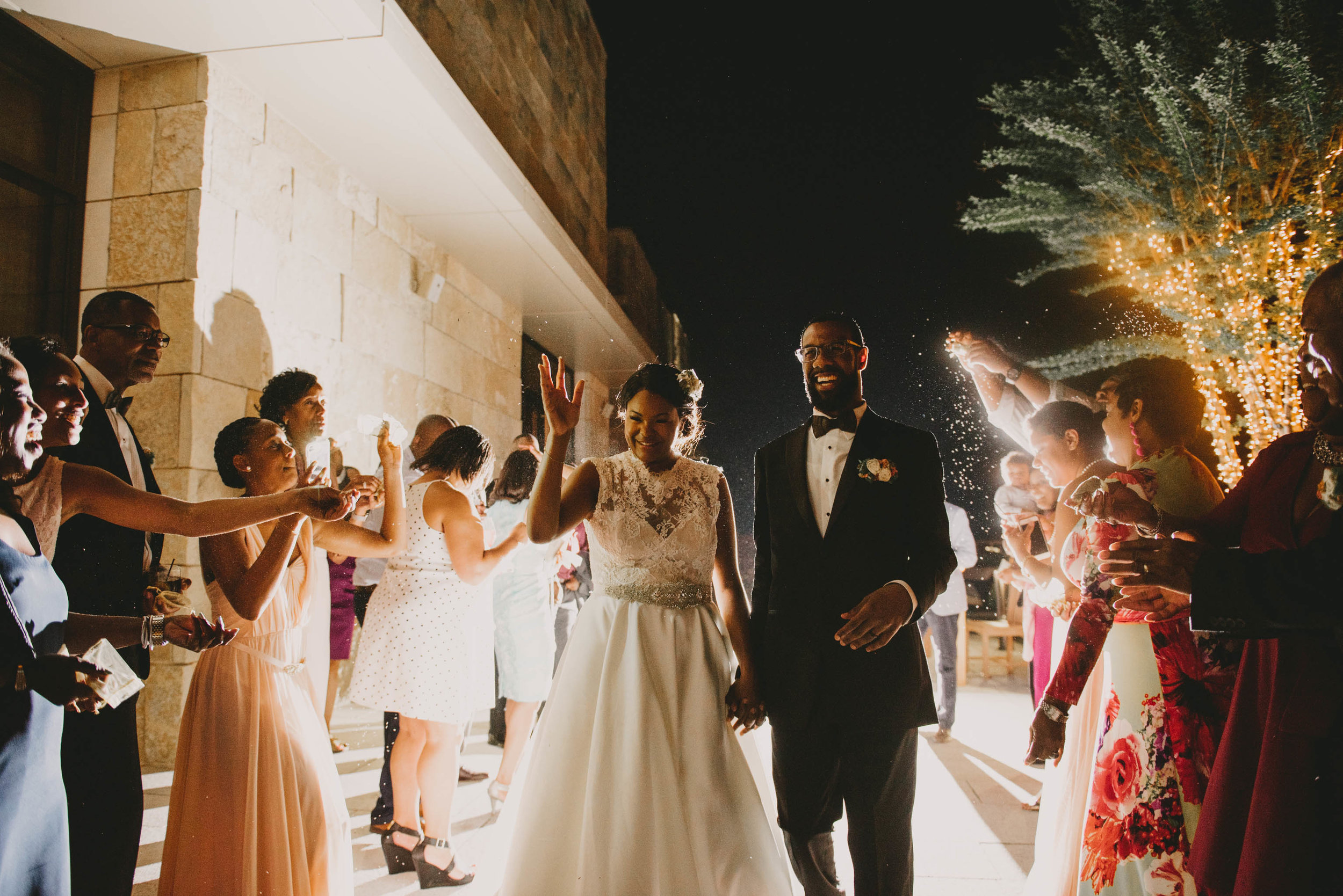 The bride and groom are showered with flowers at the exit of their Raleigh wedding