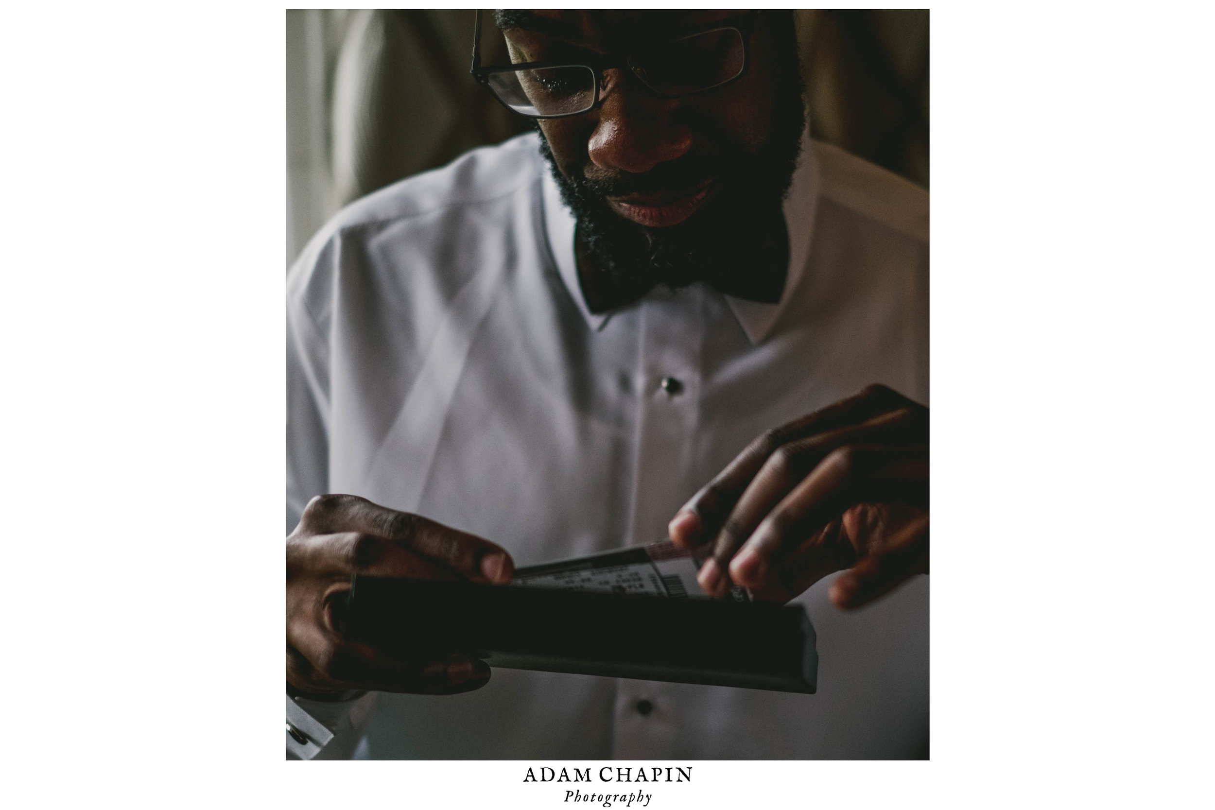 Groom crying as he opens his gift from the bride at the Umstead Hotel and Spa