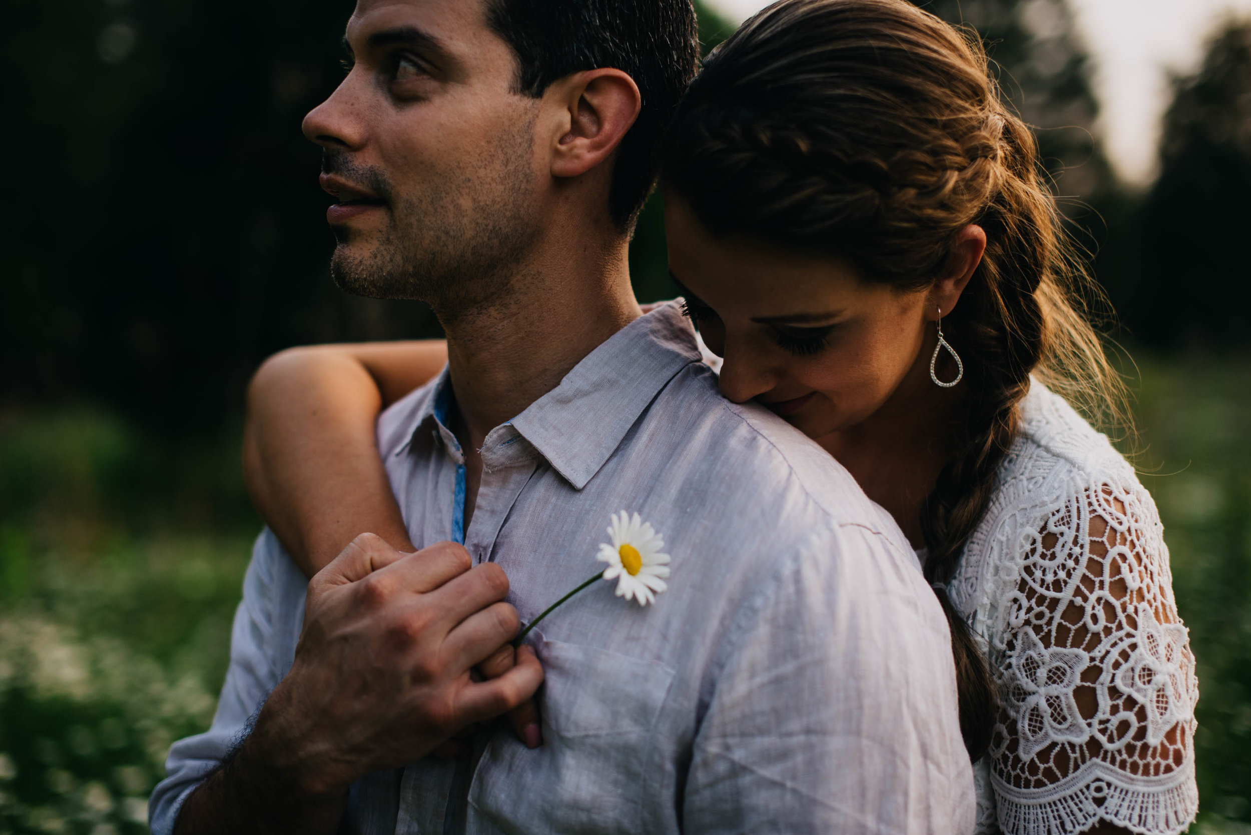 couple holding hands and embracing one another during their Eno River Park engagement