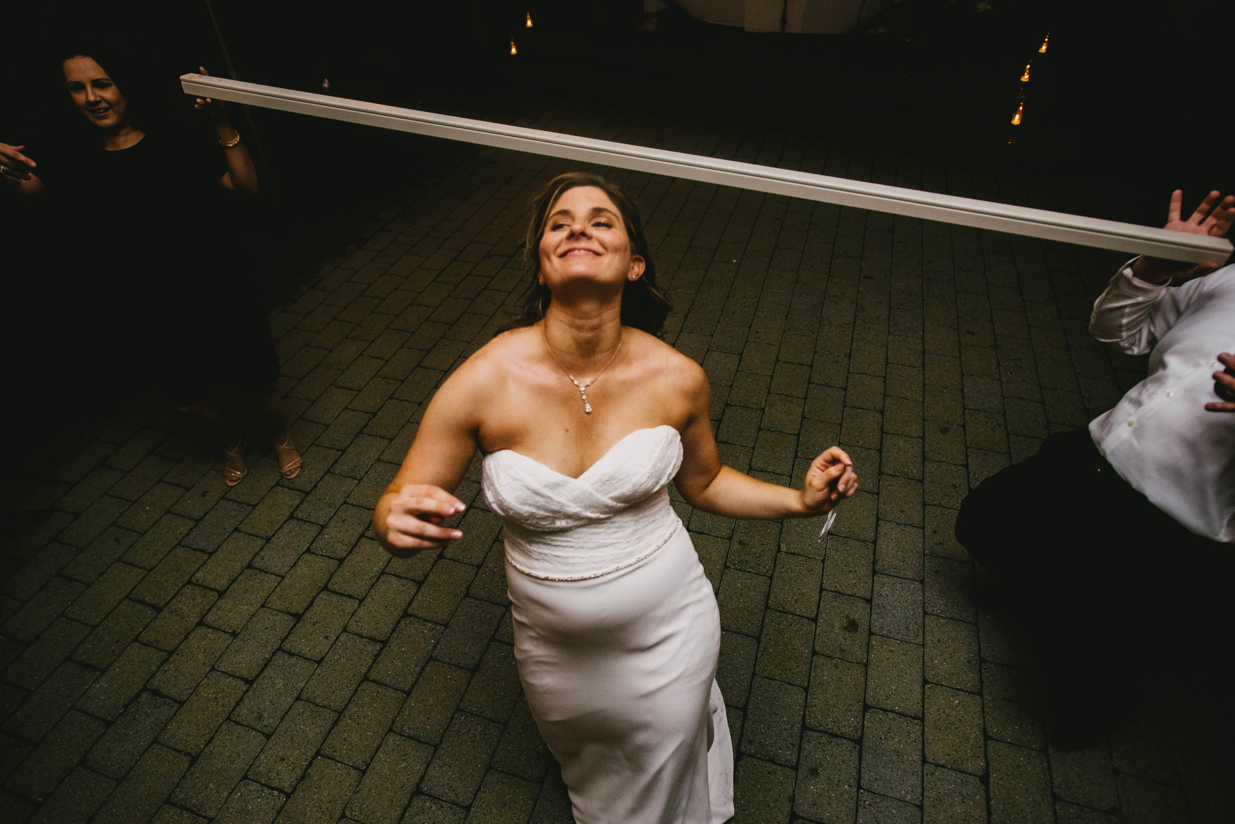 bride ducking during the limbo at her Jiddi Space and Courtyard Wedding at Sitti Restaurant