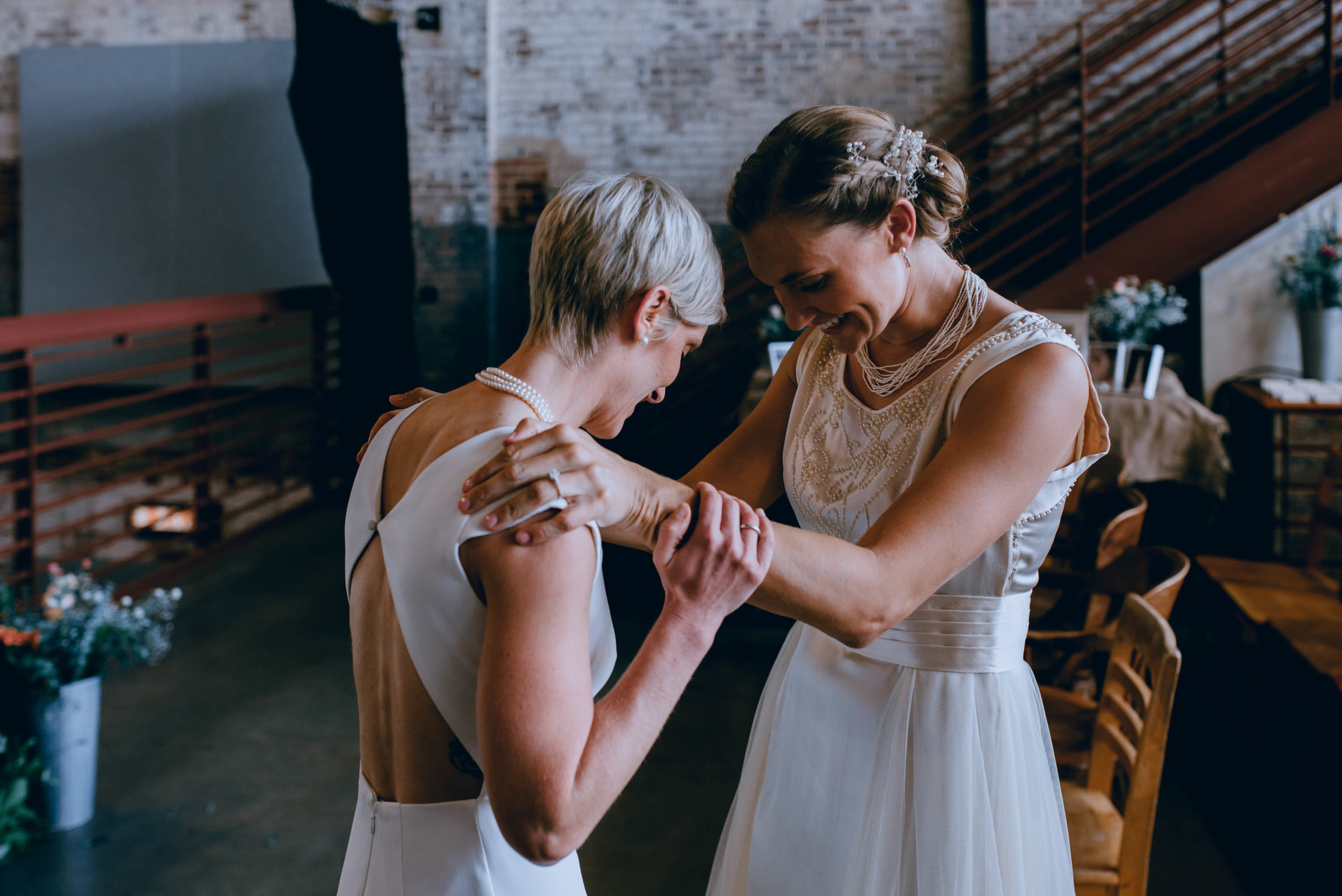 brides having a first look as each are finally dressed and ready for their haw river ballroom wedding