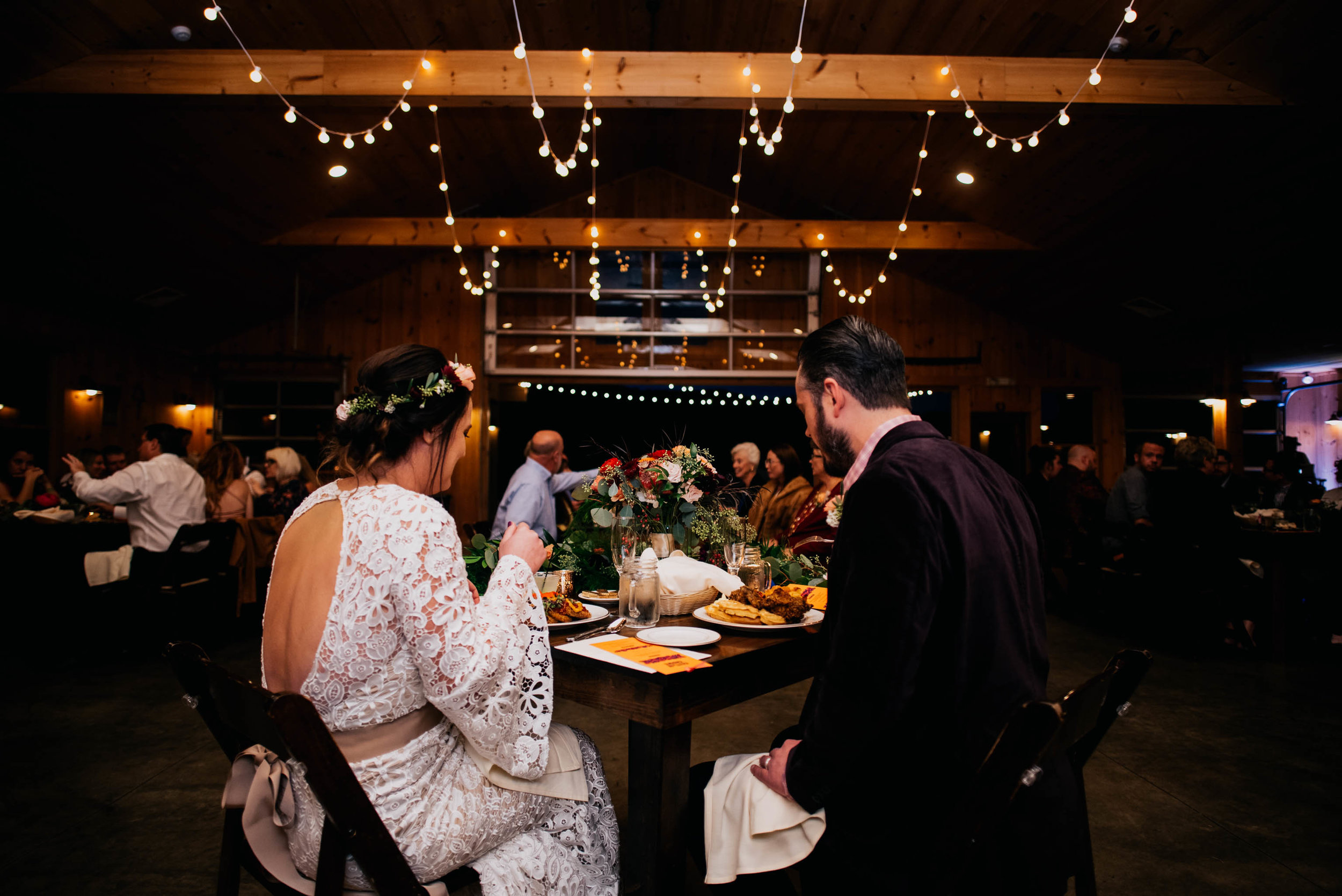 bride and groom sitting down to dinner during their reception