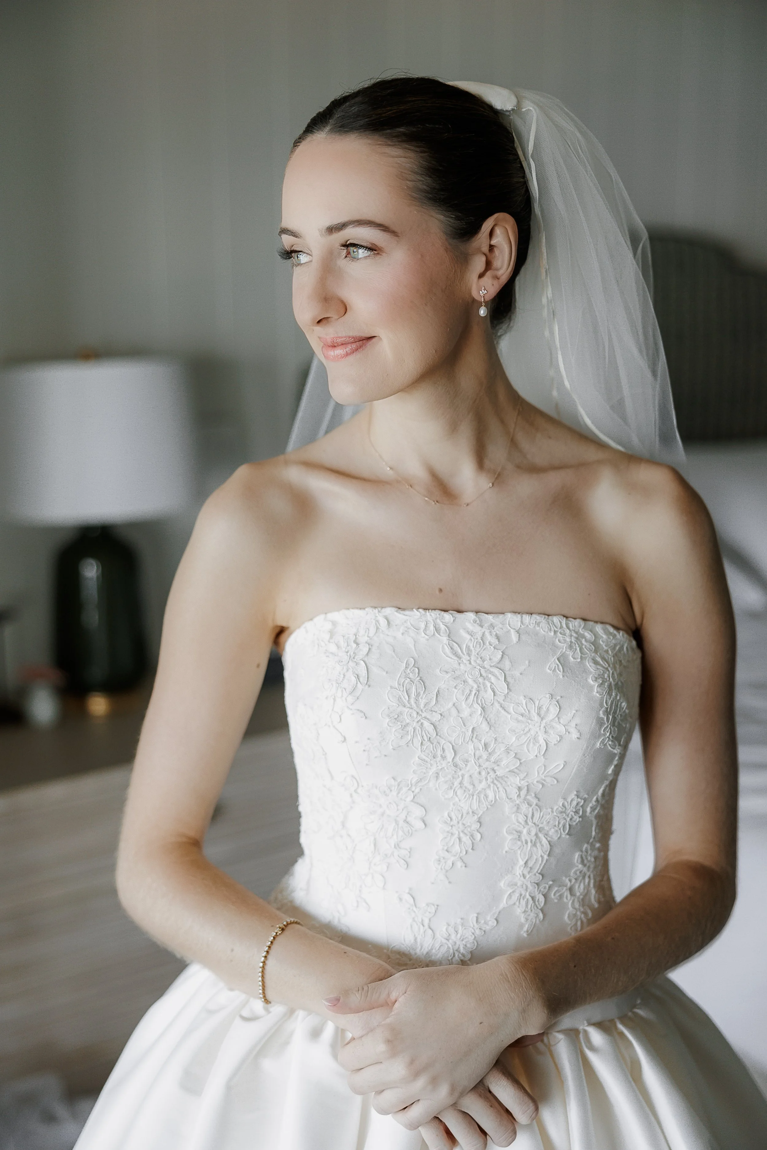 Close-up portrait of bride showing soft glam bridal makeup with luminous skin and nude pink lip