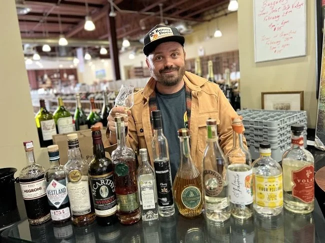 K&L Wine Merchants' Spirits Buyer David Othenin-Girard in the Hollywood location with bottles of distilled spirits.