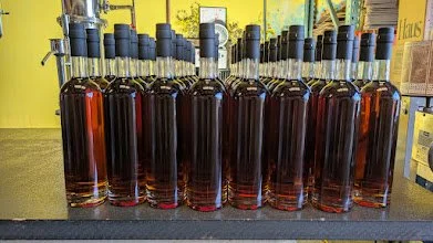 Bottles of K&L's Faultline Bourbon lined up without labels