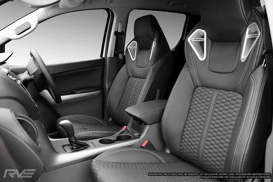 Upgraded Monza sport seats in OEM spec black leather with silver stitching and black-stitched honeycomb inserts.