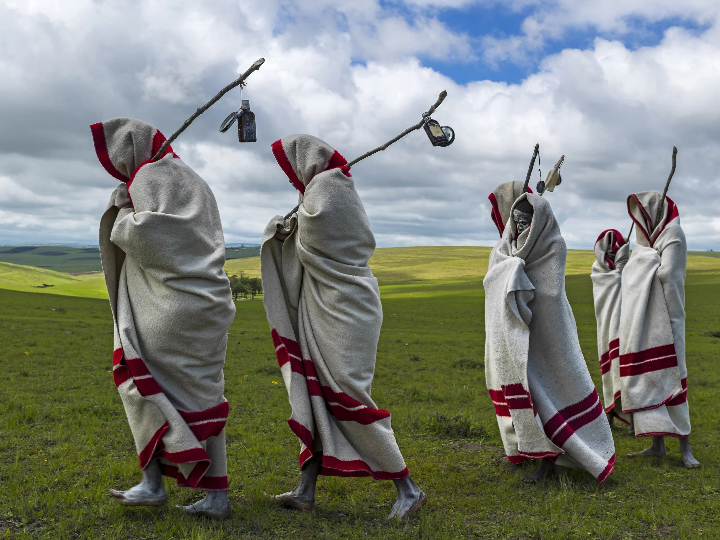 QUNU, EASTERN CAPE, SOUTH AFRICA, 14 DECEMBER 2013: Xhosa Initiates pass by close to the funeral of Nelson Mandela, Qunu, South Africa, 14 December 2014. These initiates have recently been circumsized traditionally and without anesthetic. They will spend up to two months dressed this way and learning the tradtions of Xhosa culture. Nelson Mandela, an icon of democracy, also went through this tradtional ritual. Mandela was buried at his family home in Qunu after passing away on the 5th December 2013.