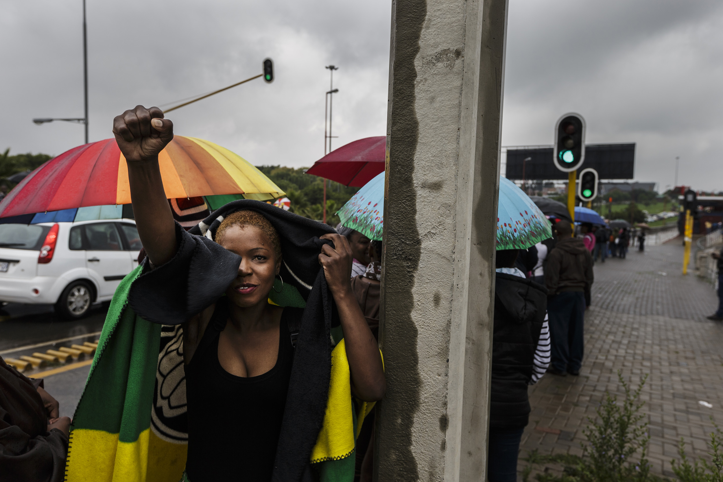 SOWETO, SOUTH AFRICA, 10 DECEMBER 2013: Mandela supporters wait for public transport in the rain on their way to FNB stadium for a day of comemoration for Nelson Mandela, the iconic Freedom Fighter of the ANC, Soweto, South Africa, 10 December 2013.