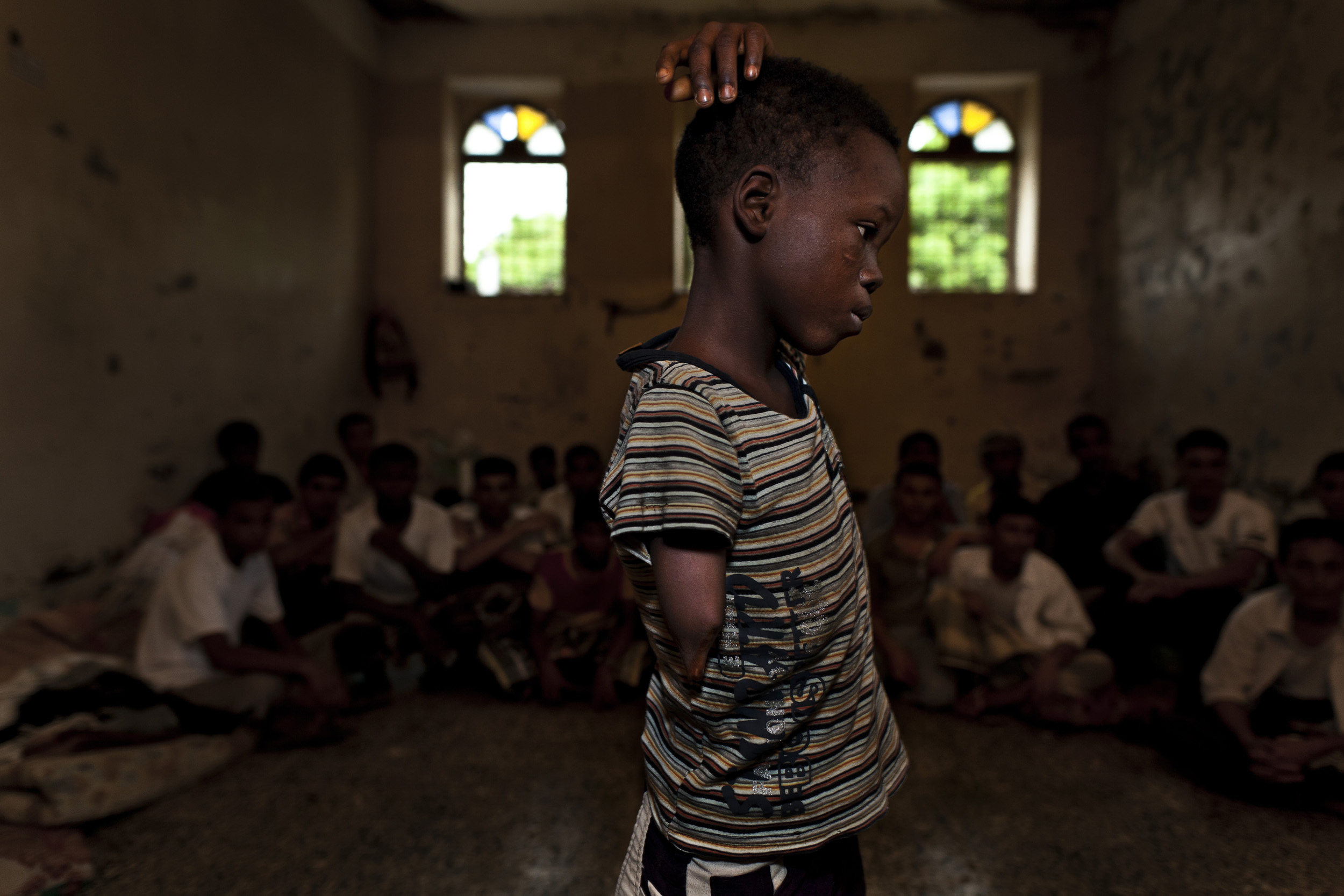 HODEIDAH, YEMEN, AUGUST 2010: An eight year old amputee Nigerian boy locked up in Hodeidah Central Prison, Hodeidah, Yemen, August 12, 2010. He is in prison with a man who claims to be his brother. They were captured by Yemeni authorities while try