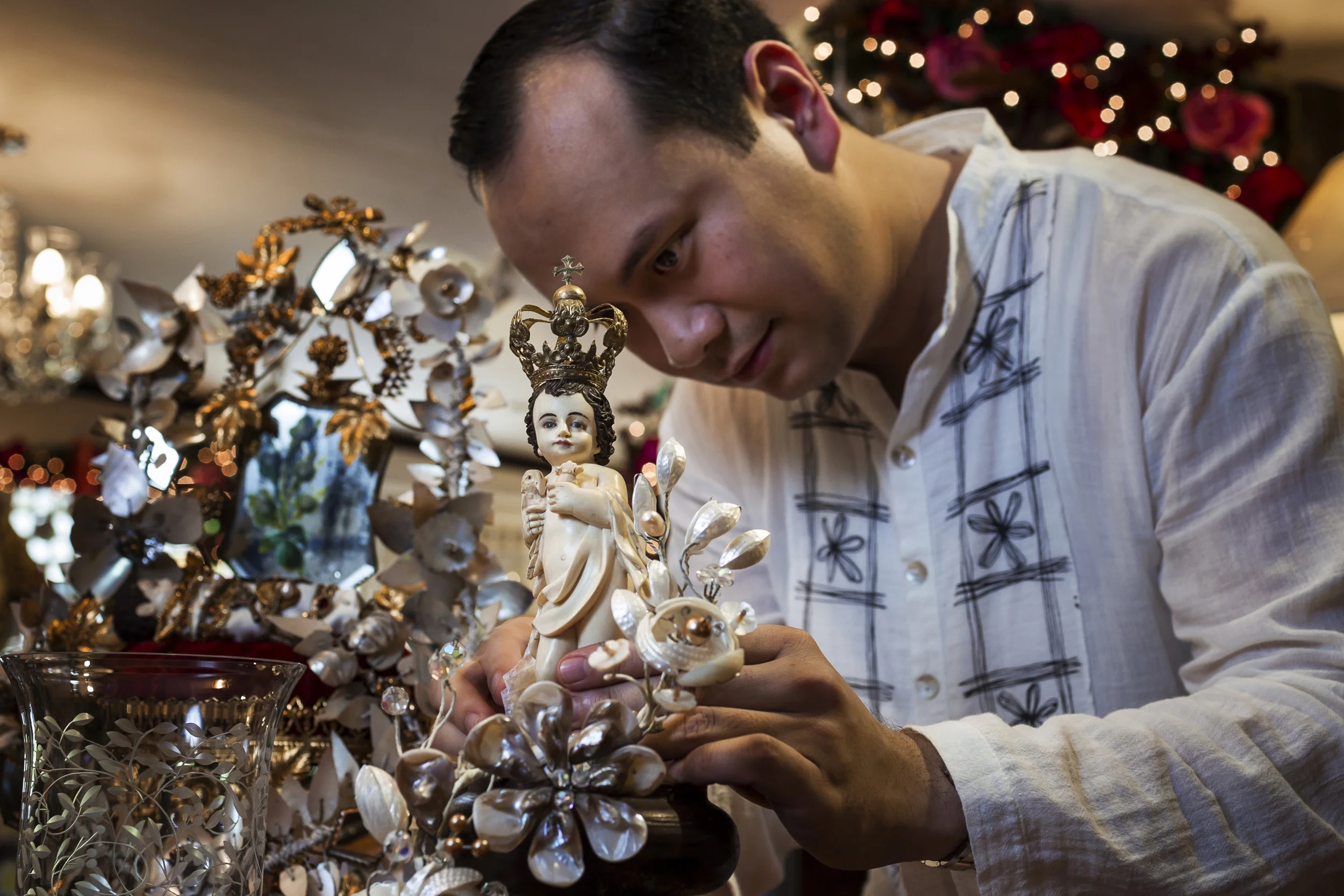 CEBU, PHILIPPINES, JANUARY 2012: A wealthy, devout Filipino man amongst his religious icon collection which is largely carved out of Ivory, Cebu, Philippines, January 19, 2012. This collection has both new and old pieces, most carved within the last 5 years. There is a collective of wealthy collectors in the Philippines who both search out and commision new work, thus sustaining a trade which allows for the continuing and growing market for new ivory. This has an inevitable effect on threatened elephant populations worldwide, accelerating demand for a commodity which is growing in value. This feature is about representing a global picture through a new and unseen lens. It places an onus of responsibility on an influential religious and wealthy elite. It offers them the chance to acknowledge their influence for good in the face of accelerating losses that are non-recoverable. It furthermore allows them to do so in the name of a value system integral to their expoused beliefs. It simply requires a reversal of priorities, from one that places iconography above life, to one that places life about iconography. This preaches a new message of compassion for all life, all God’s life, and ultimately benefits the protagonists and allows them to emerge not only unscathed but reinvigorates their standing as leaders in the value system their religious sector expouses. (Photo by Brent Stirton/Reportage for National Geographic.)