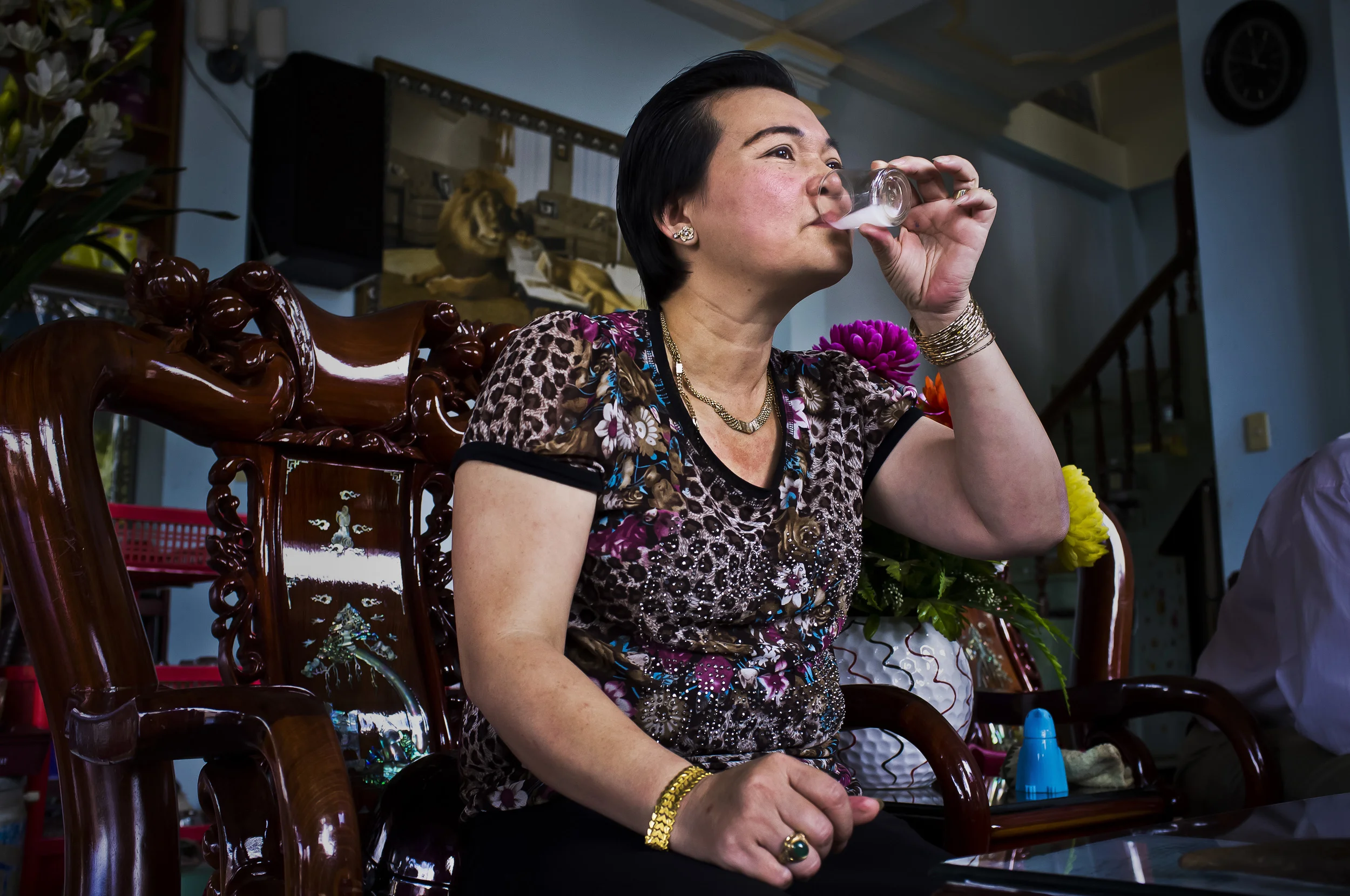 BAO LOC, LAM DONG PROVINCE, VIETNAM, OCTOBER 2011: A wealthy woman grinds illegal imported rhino horn openly in a coffee shop with her dealer sitting alongside her, Bao Loc, Vietnam, October 6 2011. The piece of horn she is grinding and the smaller piece on the table were until recently one piece, part of a larger illegal consignment which the dealer claims came into Vietnam through Malaysia or Indonesia. When asked whether they were concerned about grinding the horn in the open in a coffee shop, they laughed and said they paid the Vietnamese equivalent of $1500 every month to the police for protection. There was a policeman in the coffee shop at the time, at one point he is visible coming down the stairs. He is part of their system say the dealers. The wealthy woman claims she purchased the horn because she had kidney stones and is worried about cancer. Since using the horn, she claims to have increased energy, better skin and does not feel the kidney stones anymore. She says that she now uses the horn every day as a preventative measure. The irony of the horn trade today is that it is a centuries old practise in Vietnam, with mass belief in its power as an extractor of poisons and as a cure for measles. Nowadays however, the horn is so expensive it is only available to the upper middle class and the wealthy. The people who used it most over the centuries, ie the poor, can now no longer afford it. As a result of the demand amongst the poor, many people form groups and purchase the horn for the use of the group. (Photo by Brent Stirton/National Geographic magazine.)