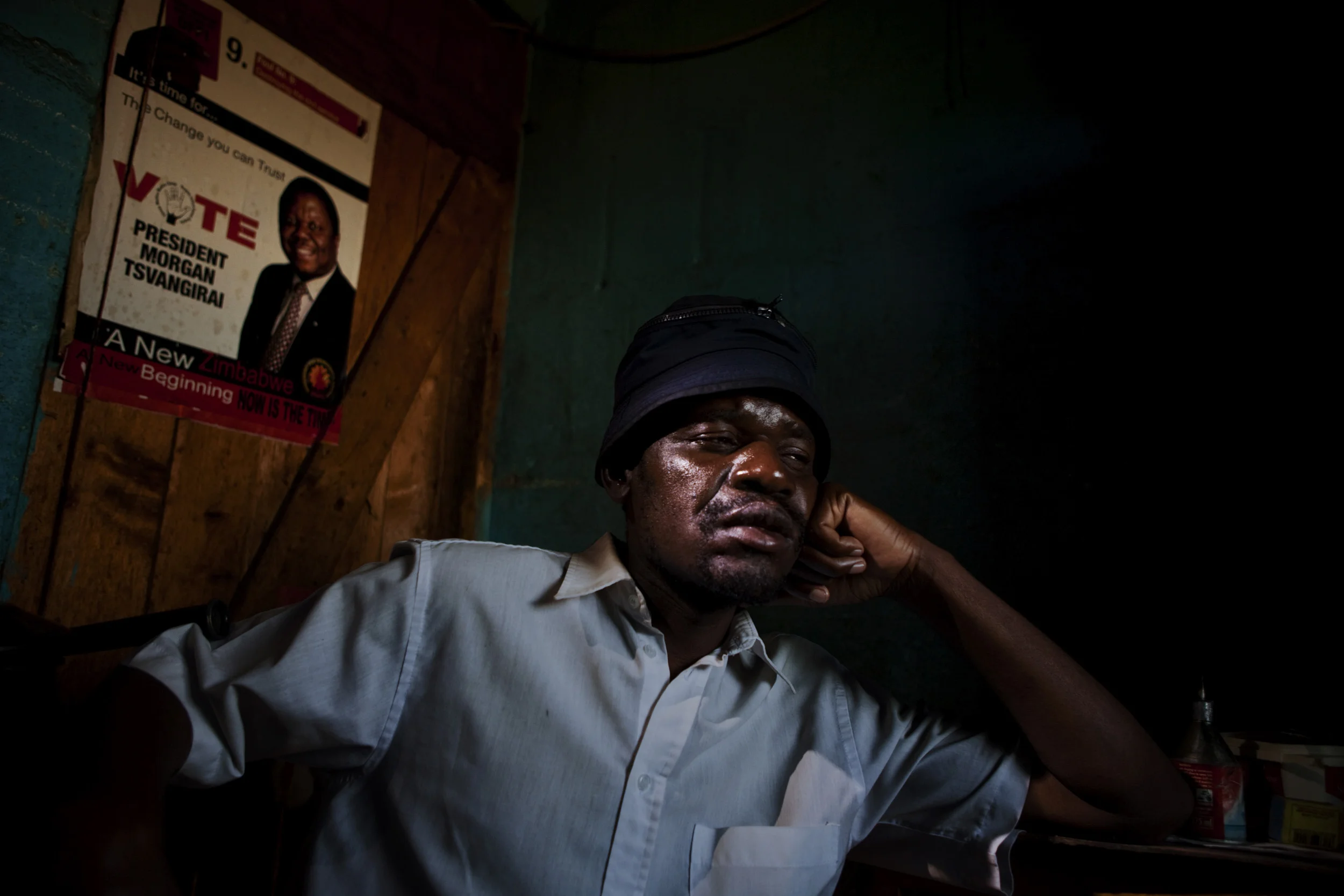 HARARE, ZIMBABWE, JUNE 2009: An MDC activist, 39, name withheld, sits quietly in a bedroom he rents in a shack in a township in Harare, Zimbabwe, 22 June 2009. He is a founder member from 1999 and presently the ward chairman for the MDC in Harare East. For his political affiliation he has been arrested more than 15 times, he has been severely tortured on 4 occasions and moved from prison to prison while being interogated by various member of the Central Intelligence Office. " I remember how there were 20 people in cell built for 3. I remember we could not sit or lie, we had to sleep standing. I remember being naked the whole time. That is where I contracted the Tuberculosis I have now. I don't worry for me, but I have a son. His mother died 3 weeks ago, also from TB. Maybe I am HIV+, I cannot afford the testing or to go on the program, the test costs what I can make in a month of vending vegetables. We have given everything for change in this country but I don't know what will happen to my son. He is only ten." (Photo by Brent Stirton/Reportage by Getty Images.)
