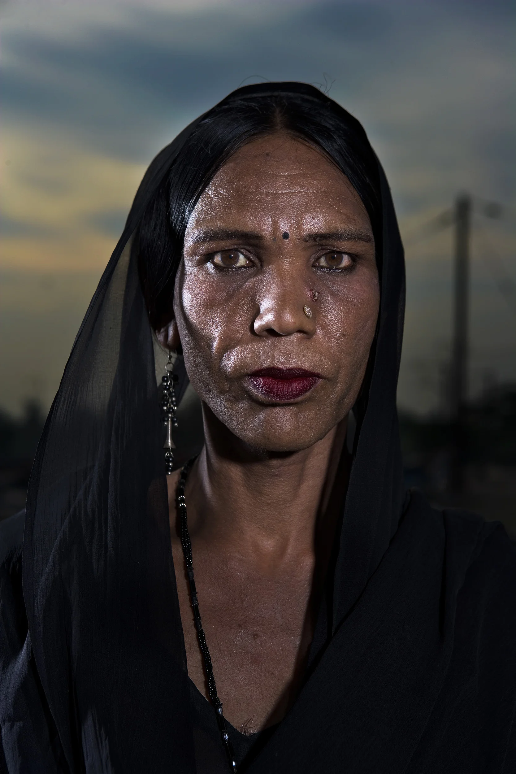 New Delhi, India, June 2006: Trans-gendered sex-workers photographed at their home in a slum in Delhi. These men live as women and are all HIV+. They have all been using IV drugs and are now being taken care of by Sahara, an Indian NGO. These trans-gendered men are all the primary means of support for their families. In two cases here the men support a wife, a boyfriend, as well as three kids. With only their bodies as sexual collateral they form a very high risk group.