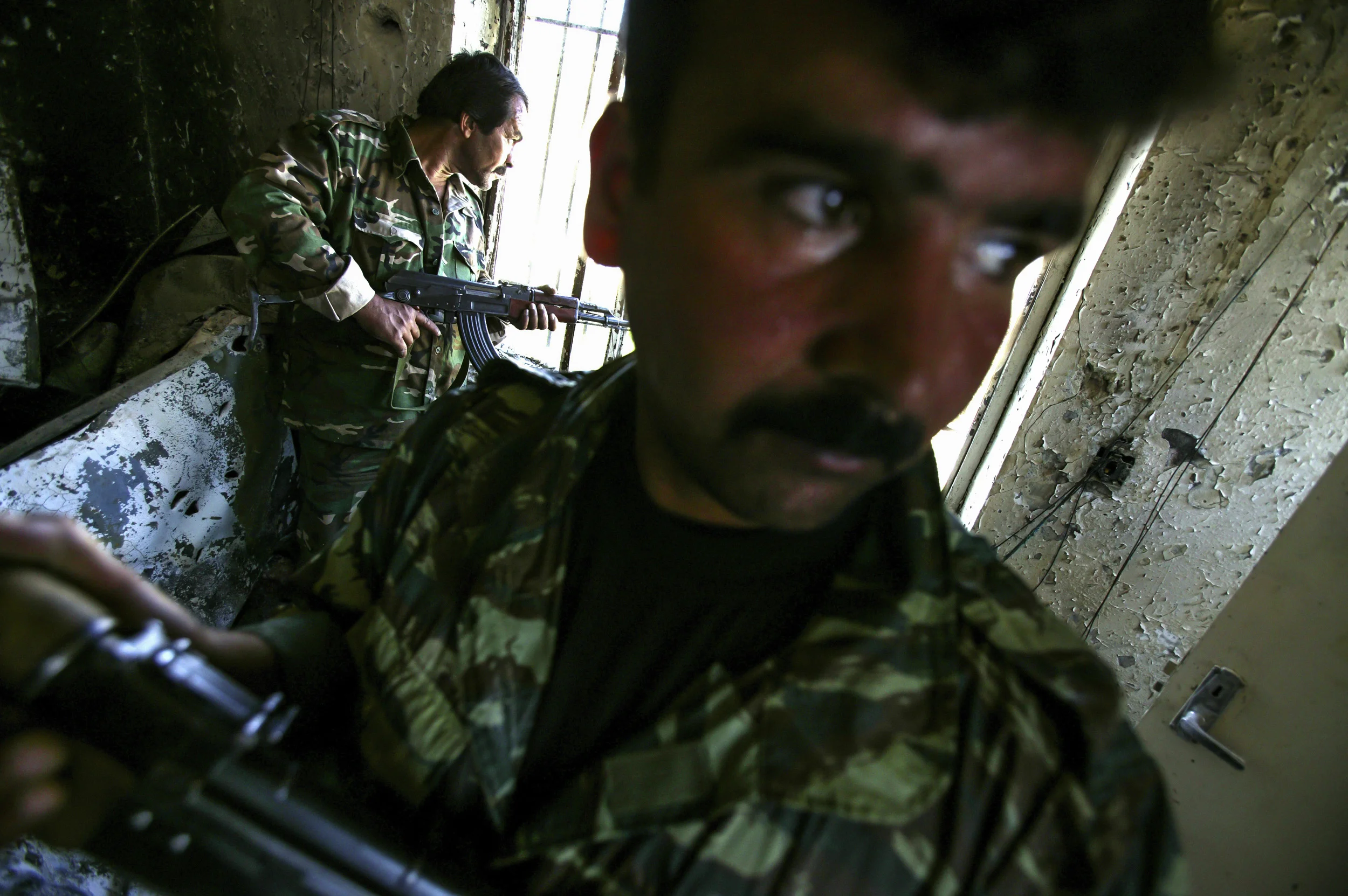 FALLUJAH,IRAQ - MAY 6: Members of the new Iraqi army do security checks on houses in Fallujah, although not yet involved in active fighting against the militia activity in the town, this new army will soon be part of ensuring security in Fallujah. The new army includes former Baathist members and members of the old Iraqi army under Sadam Hussein. The soldiers depicted are wearing the old uniform from that time. *** Local Caption *** USNWR