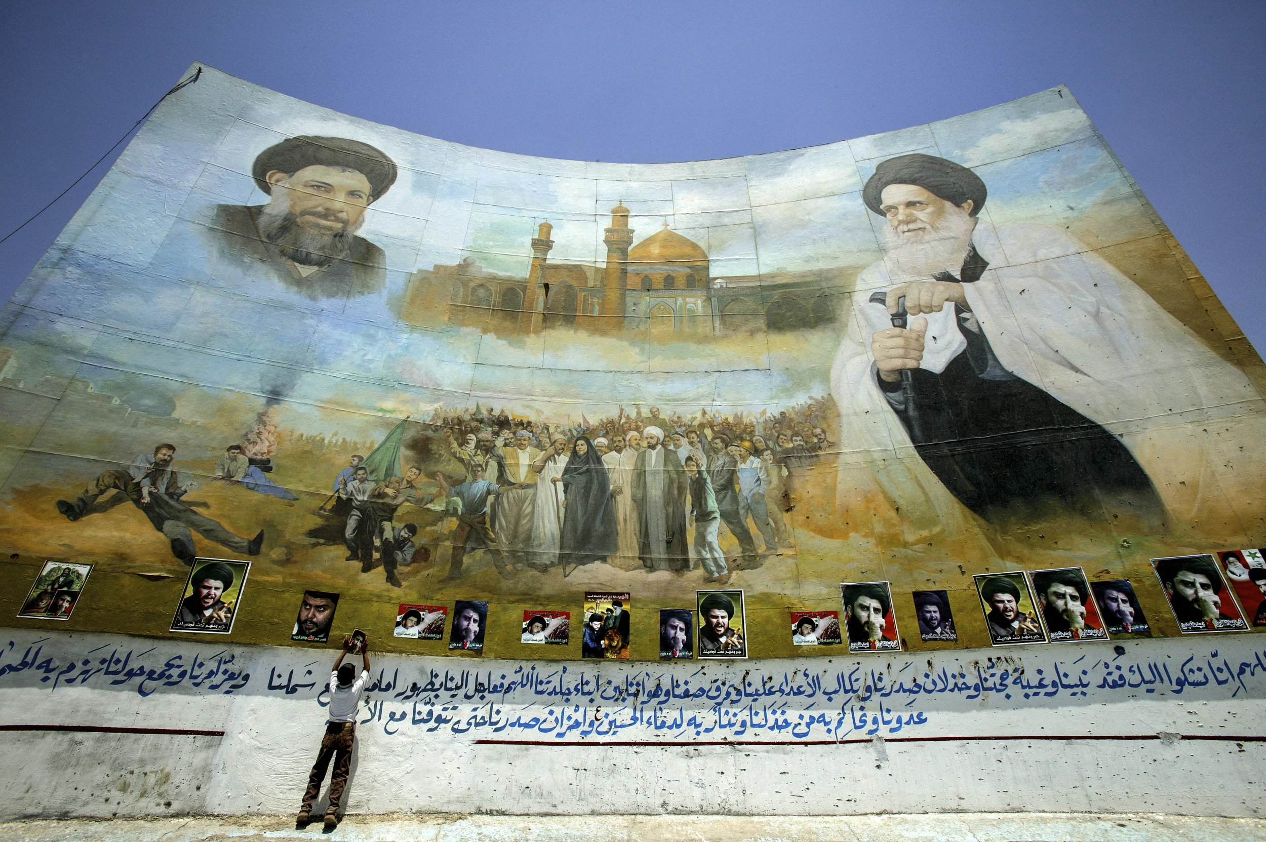 BAGHDAD,IRAQ - JUNE 03 : A huge mural in the Sadr City section of Baghdad. The mural depicts relatives of radical cleric Moqtada Al-Sadr. On the left is Mahammed Baqir Al-Sadr, a prominent cleric executed by Saddam Hussein in 1980. On the right is Mohammed Al-Sadr, the former Grand Ayotollah of Iraq. Support for Moqtada Al-Sadr and his anti-coalition sentiments continues to be strong in this area of Baghdad, as evidenced by the number of posters depicting him which have been added to this auspicious mural. (Photo by Brent Stirton/Getty Images) *** Local Caption *** Iraq Assignment