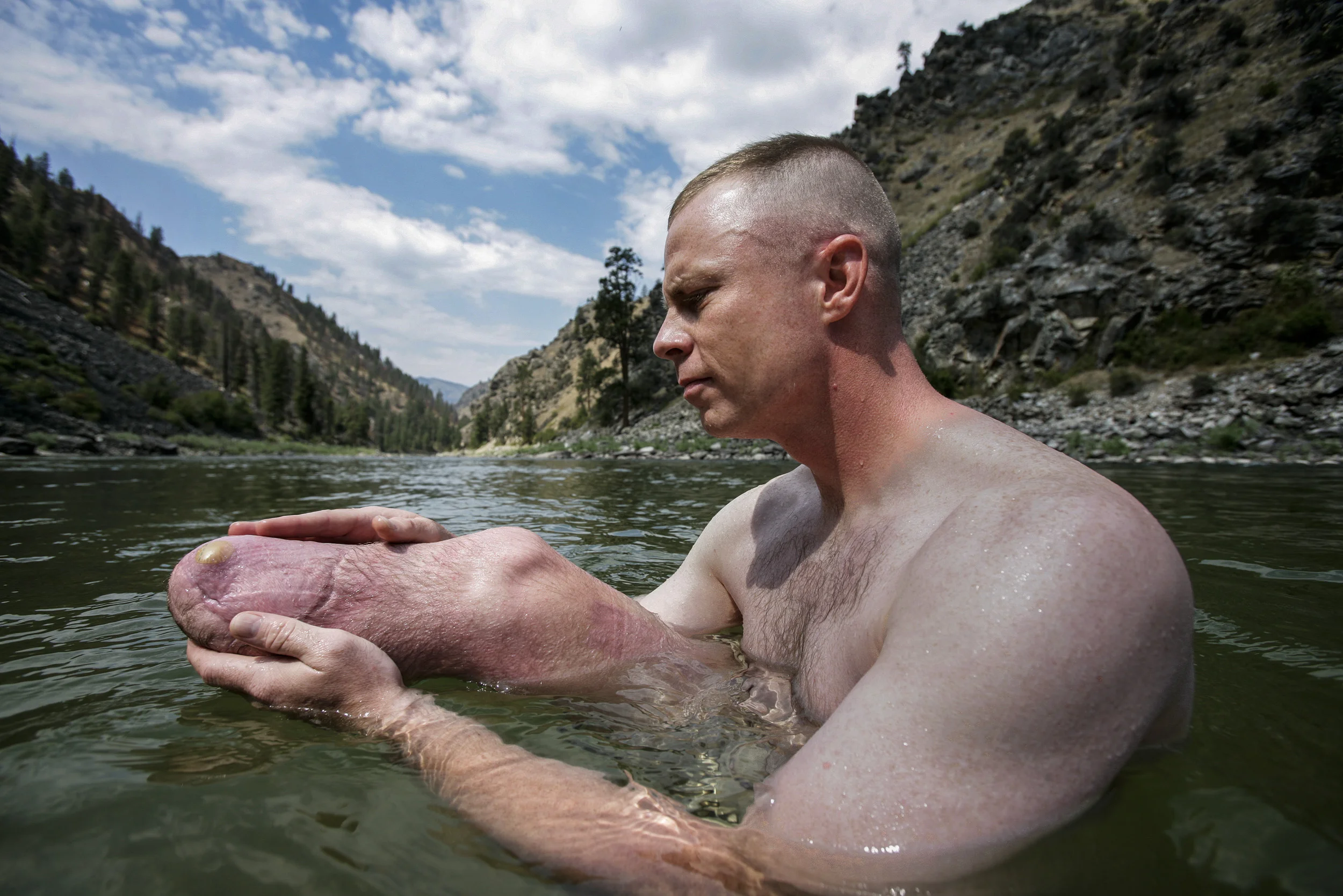 SALMON RIVER IDAHO - AUGUST 8/14 2006: Staff Sergeant Damion Jacobs, 30, examines the stump of his amputated leg after the first stretch of a river rafting trip down the Main Salmon river in Idaho. The wound is still healing and the skin has a tendency to blister and abrade. These images focus on a week in the outdoors with three disabled war wounded veterans from the Iraq, Afghanistan conflicts. Damien Jocobs,30, is a Marine Staff Sergeant with a below the knee amputation as a result of an IED explosion in Iraq.
Higher Ground is a program run by Sun Valley Adaptive sports in Ketchum Idaho. They are an NGO looking to provide a sports based meaningful rehabiliation experience for disabled veterans. The program involved taking the men, all of whom are amputees of sorts, down the Main Salmon River on a 4 day river rafting trip and then offering them the opportunity afterwards to pursue futher sporting intersts such as climbing, parasailing, kayaking and horse-riding. The program also encourages disabled veterans to bring their wives on the program. It is aimed at a healthier and speedier recovery through outdoor recreation.