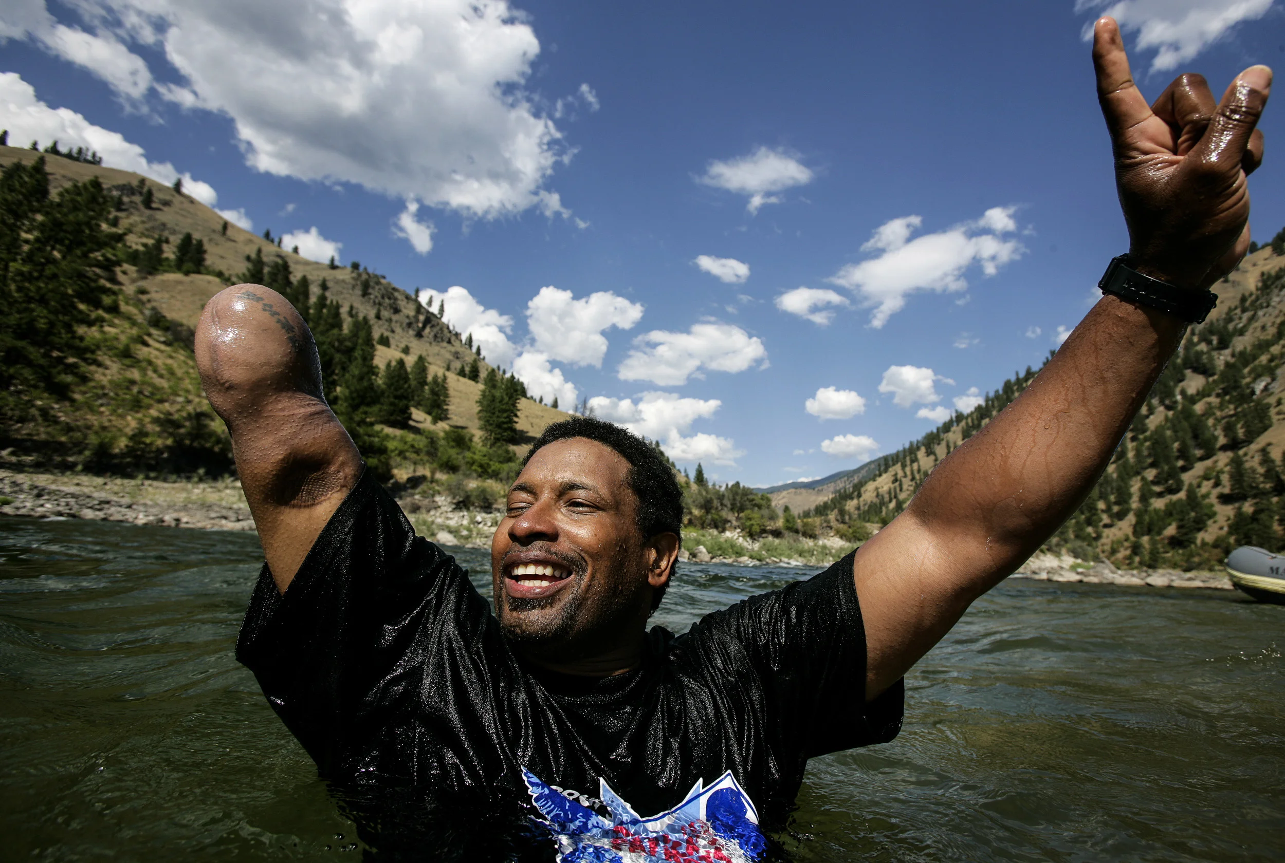 SALMON RIVER IDAHO - AUGUST 8/14 2006: Major Anthony Smith, 39, celebrates after a fun swimming race on the Main Salmon river in Idaho. These images focus on a week outdoors with three disabled war wounded veterans from the Iraq, Afghanistan conflicts. Major Anthony Smith,39, was severely wounded in the hip in Iraq while on deployment. He is missing an arm, is recovering from 4 bullet wounds and has only partial use of his right leg and hip after being struck by an RPG. Major Smith is now comitted to trying out for the US paraolympic team for 2008.
Higher Ground is a program run by Sun Valley Adaptive sports in Kethum Idaho. They are an NGO looking to provide a sports based meaningful rehabiliation experience for disabled veterans. The program involved taking the men, all of whom are amputees of sorts, down the Main Salmon River on a 4 day river rafting trip and then offering them the opportunity afterwards to pursue futher sporting intersts such as climbing, parasailing, kayaking and horse-riding. The program also encourages disabled veterans to bring their wives on the program. It is aimed at a healthier and speedier recovery through outdoor recreation.