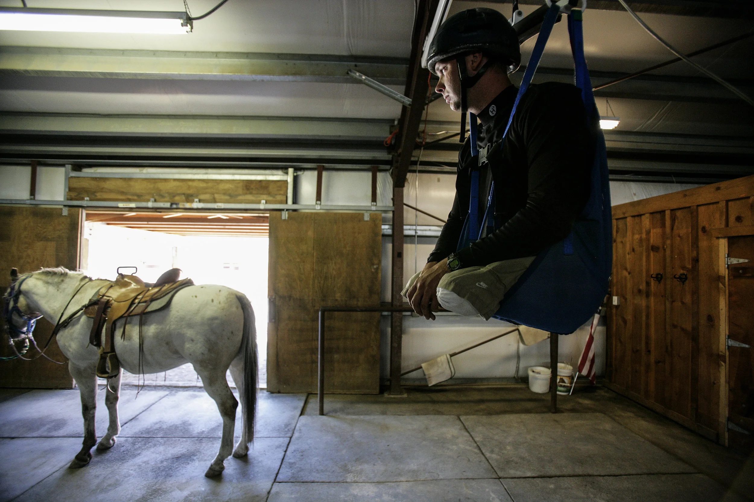 SUN VALLEY, IDAHO - 8/14 AUGUST 2006: Specialist Andew W. Soule, 25, looks across at the horse he will be riding from his elevated chair lift position. He is learning how to ride properly as part of a series of sports choices he made for a week of outdoor activity designed as part of his rehabilitation process. These images focus on a week in the outdoors with three disabled war wounded veterans from the Iraq, Afghanistan conflicts. Andy Soule, 25, is a specialist who was blown out os his vehicle by an IED in Afghanistan. Andy is a double above the knee amputee.
Higher Ground is a program run by Sun Valley Adaptive sports in Kethum Idaho. They are an NGO looking to provide a sports based meaningful rehabiliation experience for disabled veterans. The program involved taking the men, all of whom are amputees of sorts, down the Main Salmon River on a 4 day river rafting trip and then offering them the opportunity afterwards to pursue futher sporting intersts such as climbing, parasailing, kayaking and horse-riding. The program also encourages disabled veterans to bring their wives on the program. It is aimed at a healthier and speedier recovery through outdoor recreation.