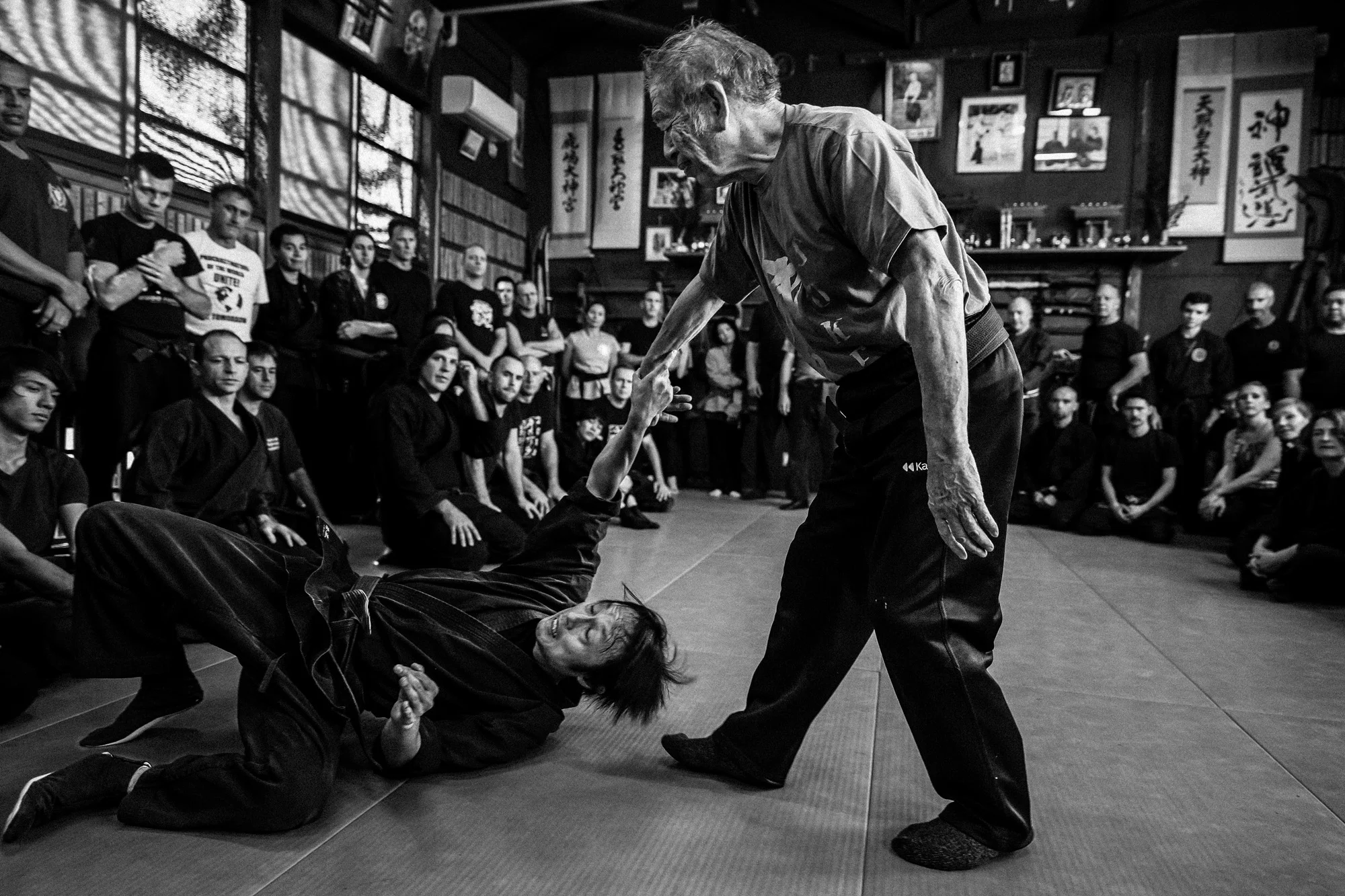 OKINAWA, JAPAN, 19 OCTOBER 2014: Sensei Hatsumi, 83, was born in Noda, Chiba on December 2, 1931. He participated in sports during his school years, along with martial arts and theater, including becoming "captain of the football team". While attending the Meiji University,,he continued learning judo and eventually rose to Yudansha or Dan rank. He also began teaching Judo during his time at the university to American soldiers at the nearby Yokota Air Base. After graduating, Hatsumi began to search for a teacher to further his study of martial arts and when he was 26 he met Toshitsugu Takamatsu, known as "the Tiger of Mongolia". Hatsumi was accepted as Takamatsu's student and spent fifteen years on Honshu Island learning various ninjutsu styles from Takamatsu and other members of the Takamatsu family, also he continued to learn judo, Shito Ryu karate, aikido, and kobudo. Masaaki Hatsumi focuses the training of the Bujinkan on the "feeling" of technique or what he terms the feeling of real situations. Hatsumi has a non-standoffish teaching approach, leading Black Belt magazine to call him "wild, funny, unpredictable, and a cross between Charlie Chaplin and Obi-Wan Kenobi." Hatsumi focuses on teaching taijutsu to his students, as the other ninja arts have no need to be practiced in modern times, besides for "historical study" He has also served as a martial arts advisor to various films and television productions, including the James Bond movie You Only Live Twice, and in the first film from the highly popular Japanese series Shinobi no Mono. He also appeared in and was the stunt coordinator for the Japanese tokusatsu television series Sekai Ninja Sen Jiraiya as the titular hero's mentor and father figure, Tetsuzan Yamaji. Hatsumi's dojo is always full, with more than 100 experienced martial artists from all over the world attending expensive classes. Hatsumi has a long history teaching the military, police and other more clandestine organizations. (Photo by Brent Stir