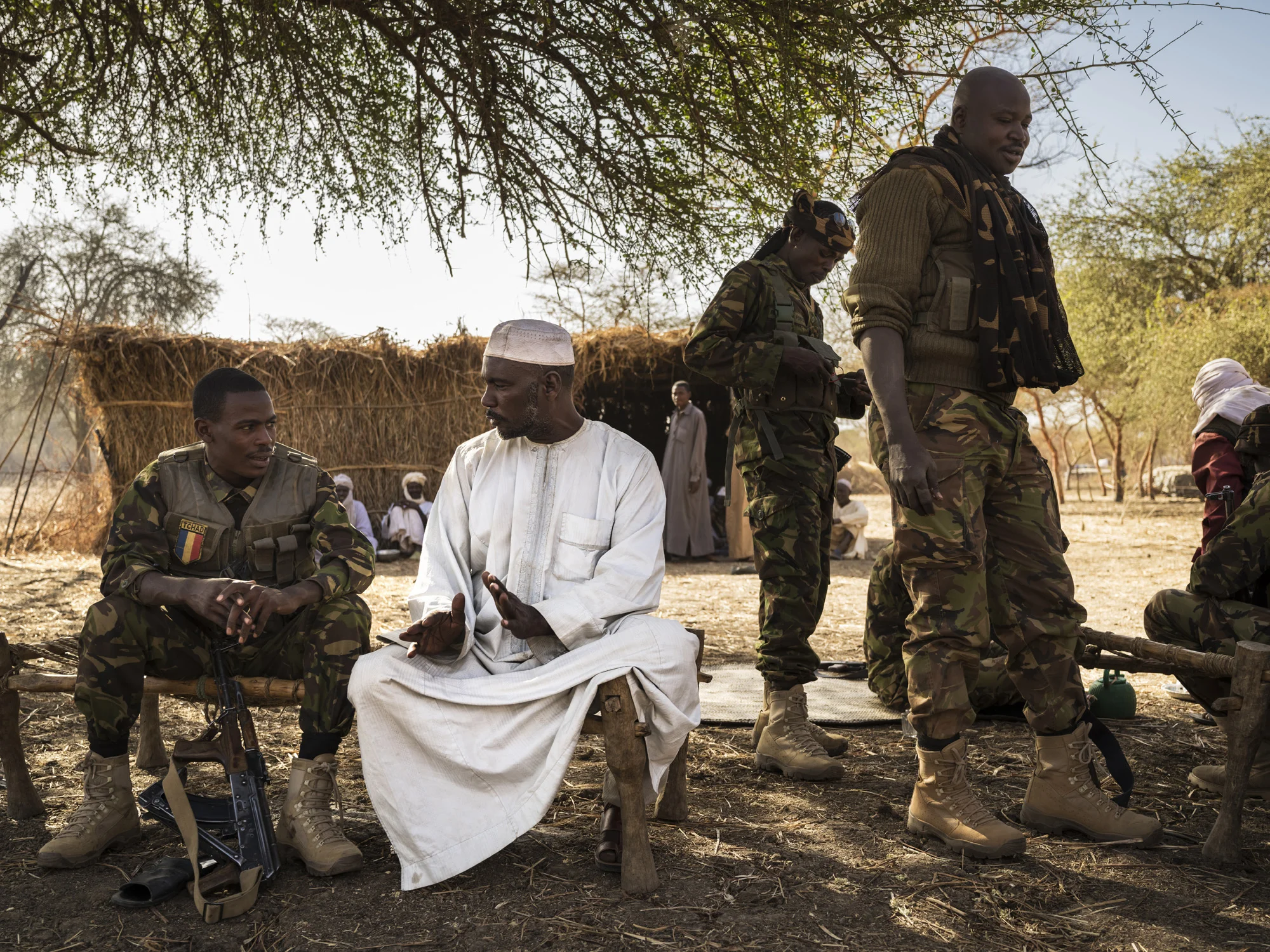NANDUMA, CHAD, 12 JANUARY 2015: Zakouma National Park Rangers interact easily with the men of a Nomad camp close to Zakouma National Park. The Park has developed good relations with the nomads and they share an intelligence network which has helped to prevent poaching. A number of Rangers come from these communities and have close ties. Zakouma is recovering from a ten year period where from 2012 to 2012 they lost 90% of their elephants, almost 4000 elephant. (Photo by Brent Stirton/Reportage for National Geographic Magazine.)