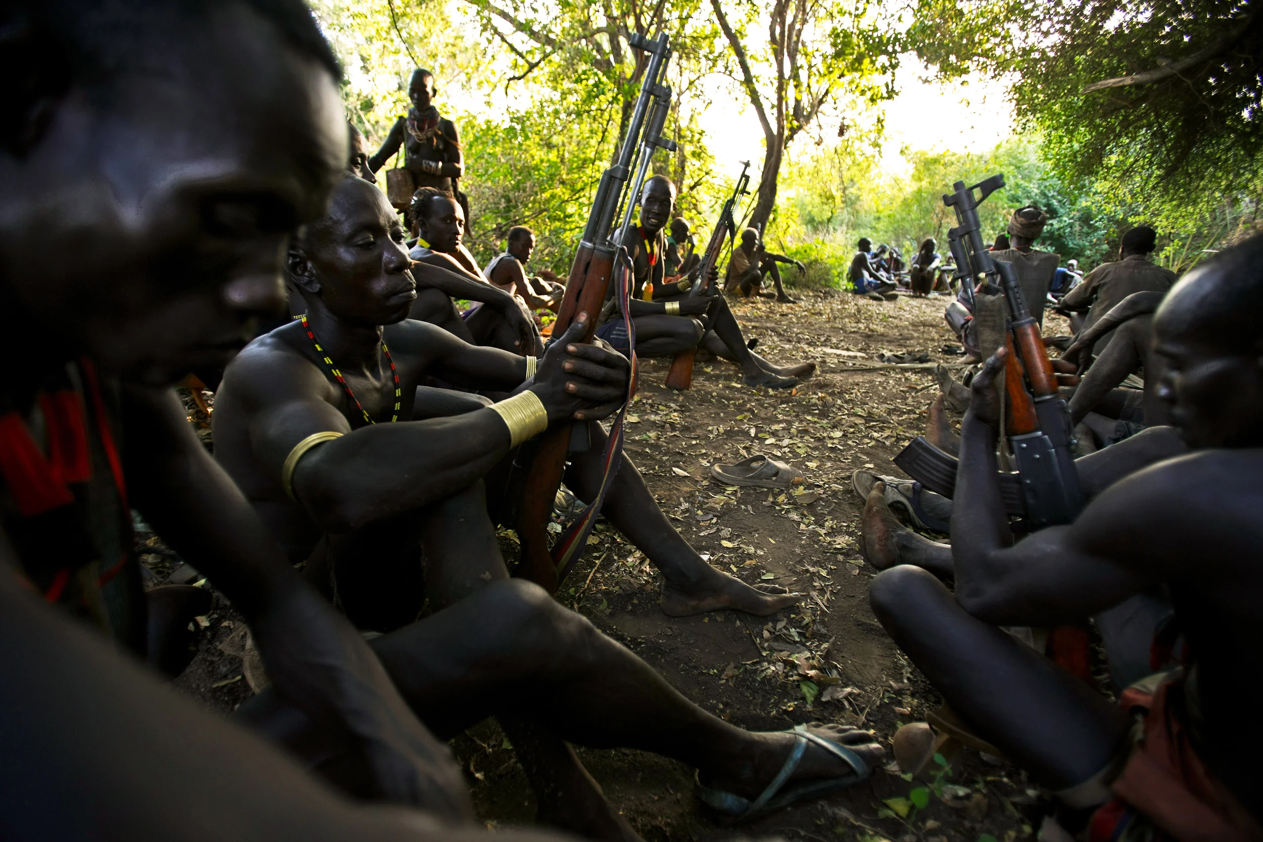 DUS, OMO VALLEY, ETHIOPIA, DECEMBER 2008: Images of armed Karo tribesman preparing for clashes with Bume people who have fired on them over a water rights dispute along the Omo river in the Omo Valley, South West Ethiopia, 14 December 2008. The Karo, with a population of about 1000,are a small group of people who live on the east banks of the Omo River. They are surrounded by relatively wealthy and strong groups,in terms of cattle and population size. The Omo river is severely threatened by the Gibe 3 dam project currently under construction by the Ethiopian government for hydro-electric purposes. There has been no environmental assesment study for the dam and it is likely to lower the Omo River level to one fifth of its current flow, thus removing the fertile flood plain utilised by the agro-pastoral tribes of the Omo Valley. The Omo River is also the chief tributary for Kenya's lake Turkana, just over the border, and thus the dam project is also likely to impact all the tribes living on Lake Turkana's shores and increase the conflicts over scarce agricultural and water resources. Karo, whose neighbors especially the Hamar (to the South East ) ,Bana (to the east ),Bashada (to the East ), the Mursi (to the North)and Nyangatom (to the west across the Omo river ) know them by the name Kara,speak a south Omotic language.The main subsistance crops of the Karo are sorghum ,maize and beans .They are supplemented by bee-keeping and more recently fishing.They plant fields using rain,flood retreat and river bank cultivation but the most important source of grain production is river bank farming than the other two which is carried out both along omo river and on the shores of Lake Diba.The Karo used to have big ,magnificient houses when they were rich in cattle but after they have lost their wealth through tsese fly they adopted the much lighter conical huts of the Bume.Every karo family own two houses-the conical shaped Ono which is the principal living room of the family an