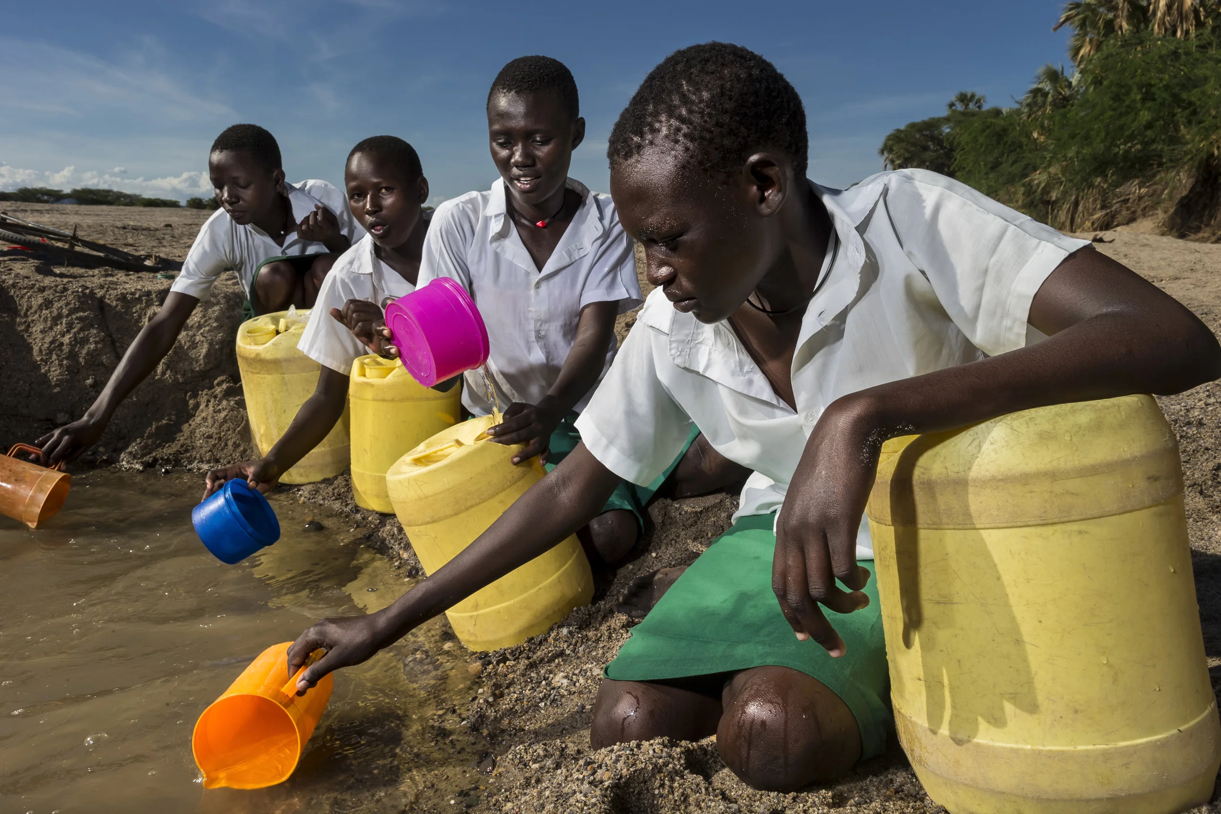 KALOKOL, TURKANA, KENYA, 8 OCTOBER 2014: Girls from Kalokol Girls Primary school collect water from a dry river bed as their school does do not have access to running water. The girls take it in turns to fetch water daily from a dry river source which sees them exposed to potential danger and taking time off from their studies to walk the two hour round trip it takes them to fetch water. (Photo by Brent Stirton/Reportage by Getty Images for HRW. )