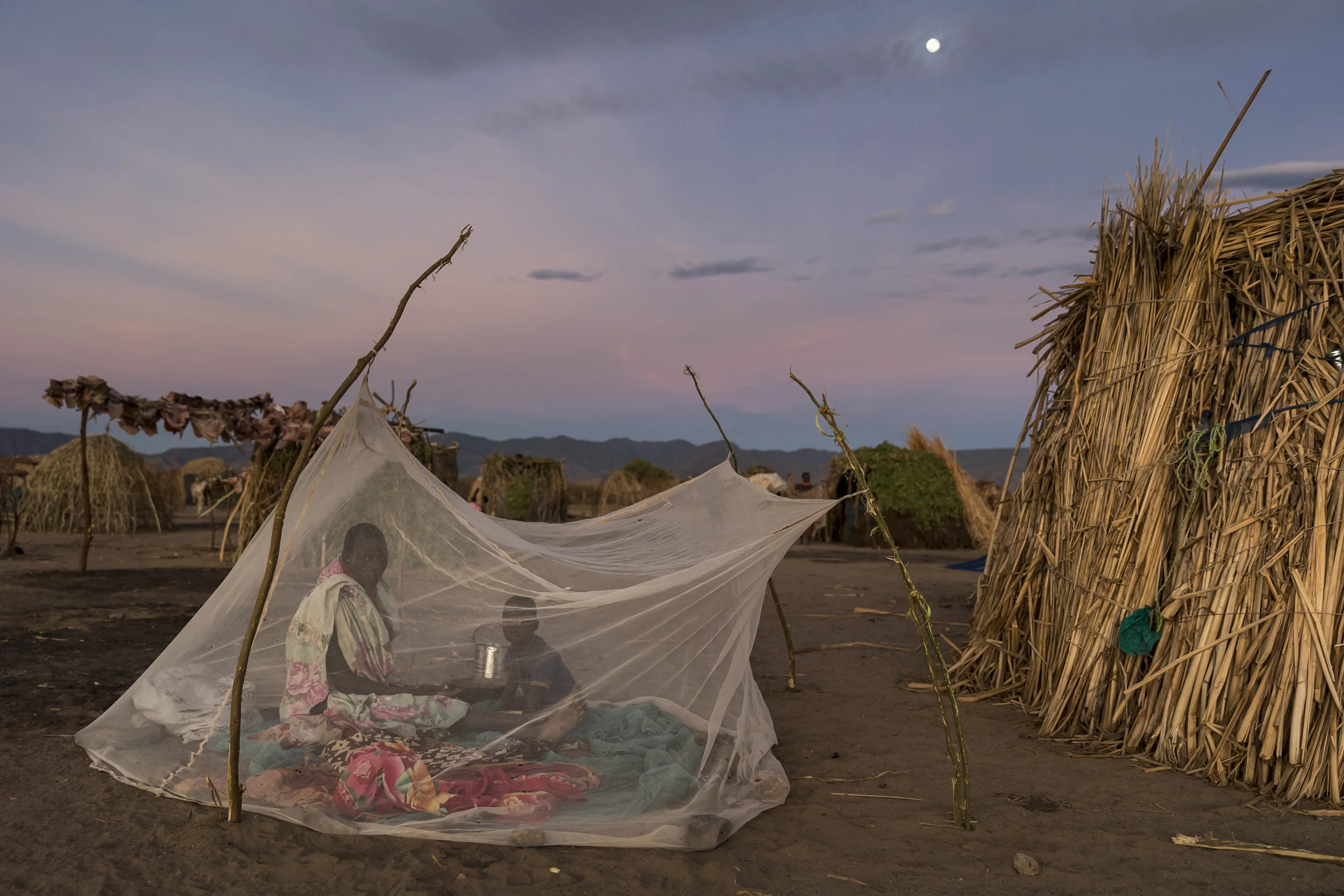 LOWARENGAK, TURKANA, KENYA, 10 OCTOBER 2014: Images from an internally displaced Turkana community who have been moved off their land by Dassanech tribesman who raided their cattle and killed their people, Turkana, Kenya. These Turkana now practise fishing as opposed to their traditional pastoralism as their main means of subsistence. The Dassenech have in fact come illegally over the Ethiopian border into Turkana land. They were pressured by sugar cane farms on the lower Omo river which is the main tributary for Lake Turkana, the largest desert lake in the world. These sugar cane farms robbed the Dassenech of tradional grazing land and water rights and so they moved over the border into Turkana territory and ongoing conflict is the result. This pattern is likely to increase as Ethiopia's Gibe 3 dam comes online next year. This will reduce the flow of the Omo river to one fifth of its current size. This will decimate the fertile flood plain in the region and the tribesmen along the Omo will fight for diminishing resources as a result. This conflict will be likely to continue in Kenya's Turkana region as all around the lake hundreds of thousands of tribespeople will find themselves competing for less and grazing, fishing and clean water sources. A series of droughts have reduced most of these pastoralists to fishing as their chief source of subsistence due to huge cattle and goat deaths. The massively reduced flow of the Omo, source of 90% of Lake Turkana's water, could have a devastating effect on this food and income source. The Ethiopian government has conducted no Environmental Impact Assessment for their dams and has yet to respond to these issues. (Photo by Brent Stirton/Reportage by Getty Images for HRW.)