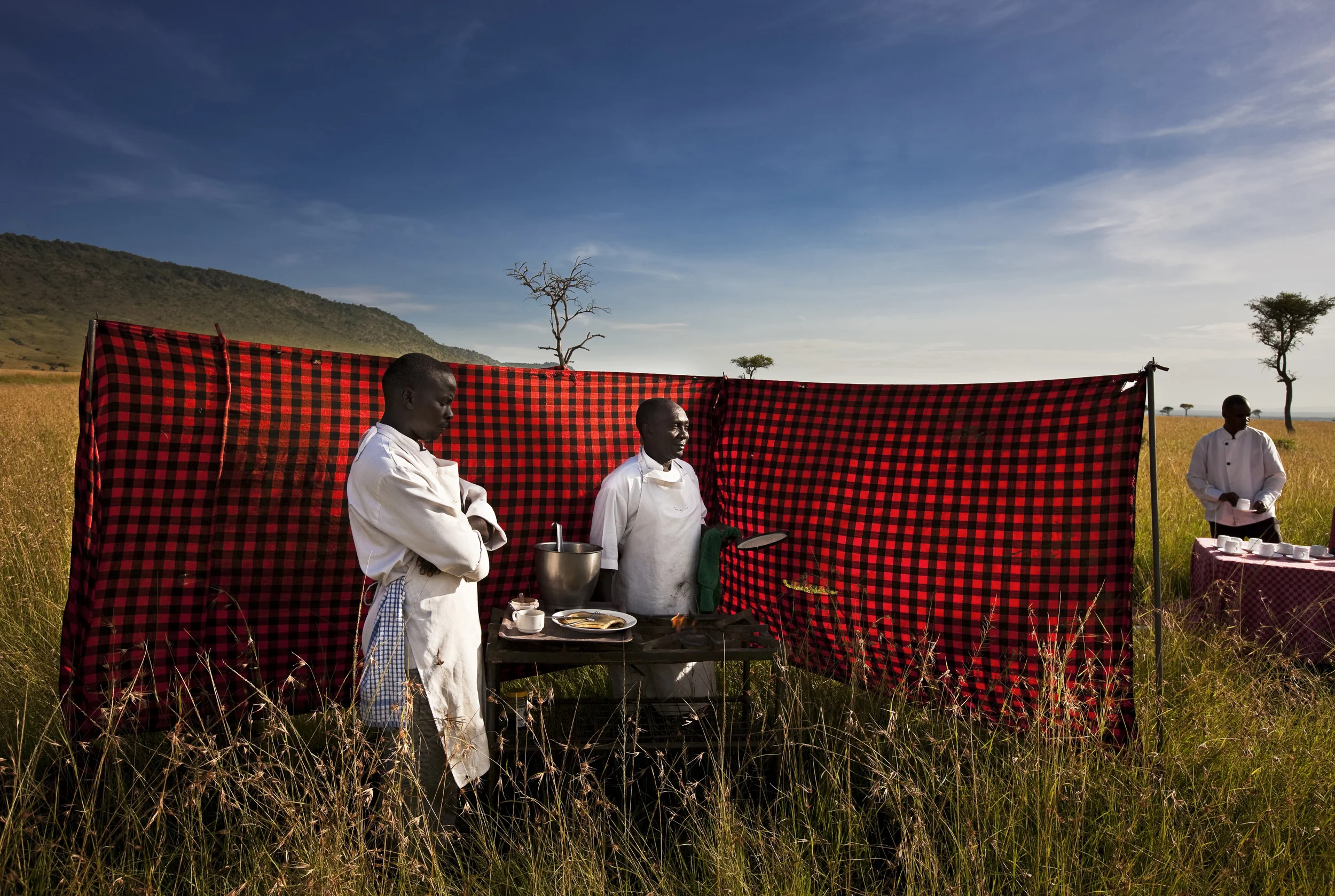 MASAAI MARA NATIONAL RESERVE, KENYA, FEBRUARY 2010. Kenyan men who are former pastoralists now working for an early morning ballon ride service inside the Masaai Mara National Reserve, Kenya, 25 February 2010. Pastoralist throughout Kenya are in transistion, affected by land pressures, drought, insecurity and competition for grazing lands, many are turning towards Kenya's conservation and tourist industry for security and income. Some of that is manifesting in land leasing by various tribes to tourism operators, others are working directly in tourism in the game parks like these three men who are chefs at Governor's Camp in the Masaai Mara Nature conservancy reserve. (Photo by Brent Stirton/Reportage by Getty Images)