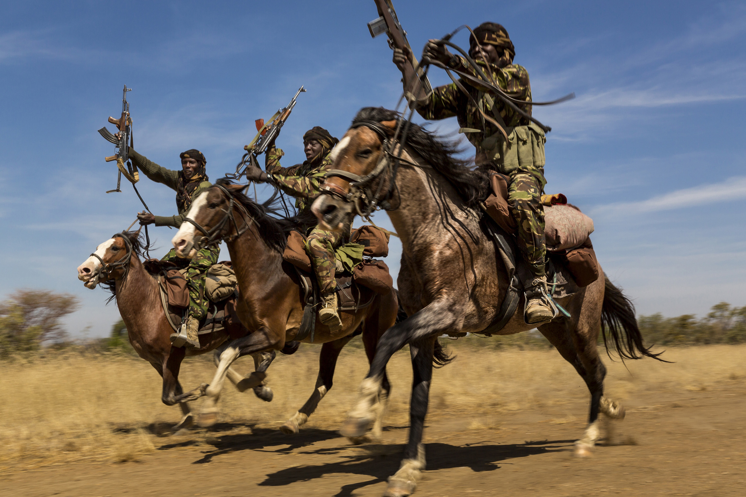 ZAKOUMA NATIONAL PARK, CHAD: Rangers from a horse patrol group exhibit their riding skills as they return to base at Zakouma National Park, Chad. The horse patrols are the old guard of Zakouma's rangers and have seen a good deal of conflict in their