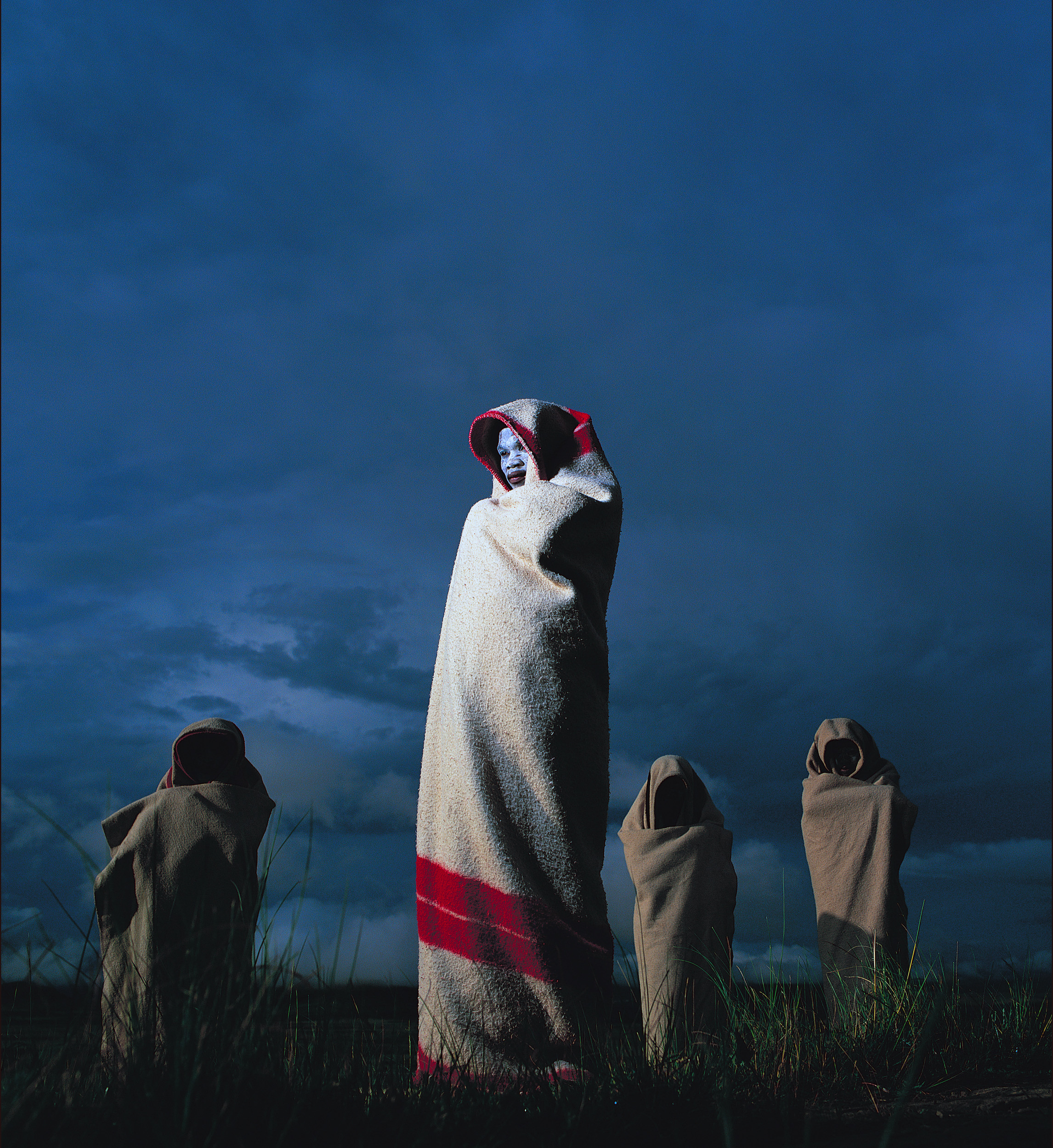 TRANSKEI COAST, SOUTH AFRICA-NOVEMBER 2003: Xhosa boys undergoing the circumcision ceremony walk back to their huts at the end of the day. Every Xhosa male must undergo this ceremony which begins with a unanethatised circumcision and then explores a