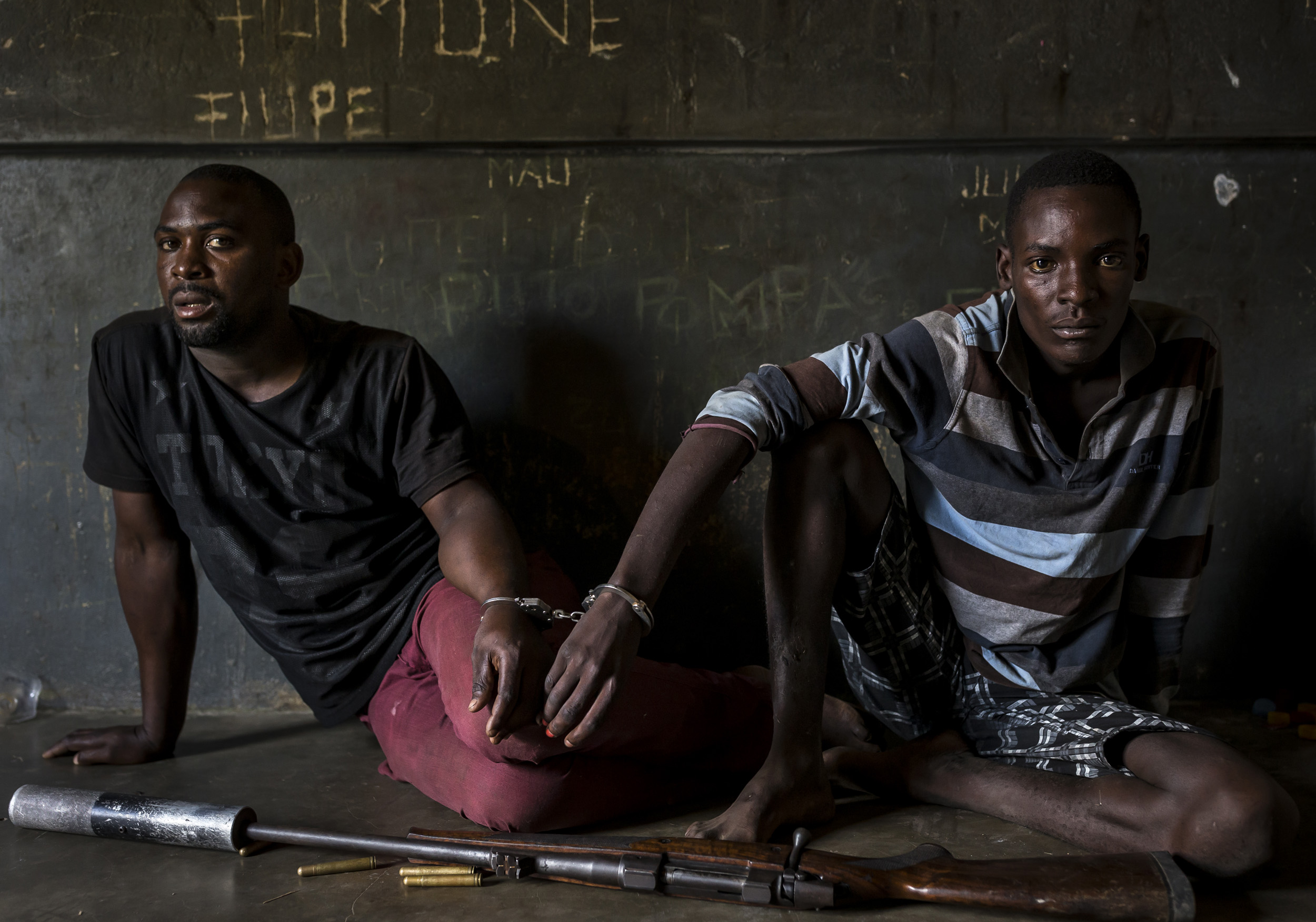 MOAMBA, MOZAMBIQUE, 19 APRIL 2016: Two rhino poachers, one 19, the other 28 years old, apprehended by an anti-poaching team in Mozambique close to Kruger National Park border. They are seen waiting to be processed in the local jail. After a three da