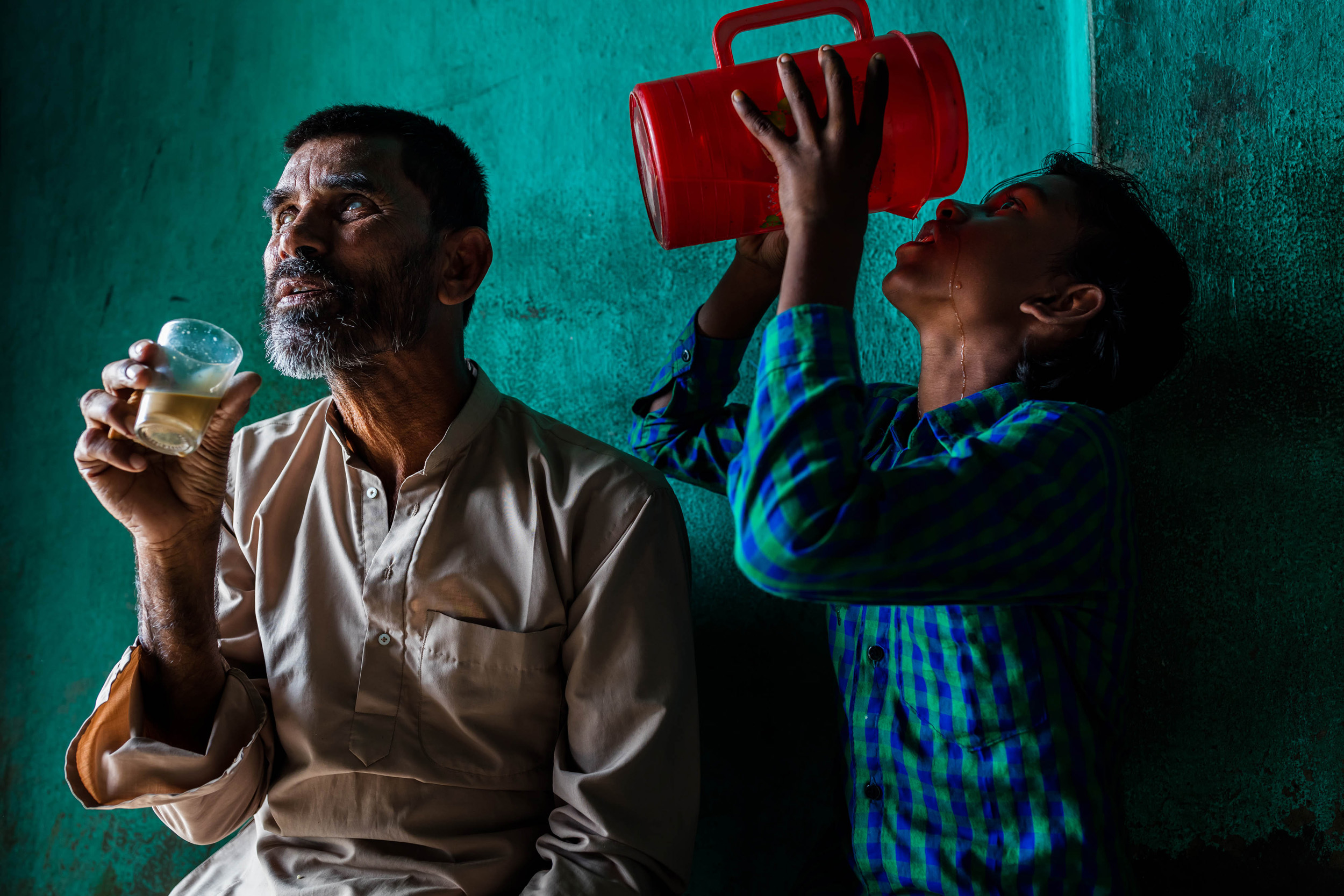 SUNDARABANS, WEST BENGAL, INDIA, 8 JANUARY 2016: Mahammad Ali Molla, 60, has been blind for the last 14 years. He goes for tea every day and his grandson accompanies him on the 2 kilometer walk to the local market. He also assists him as he drinks a
