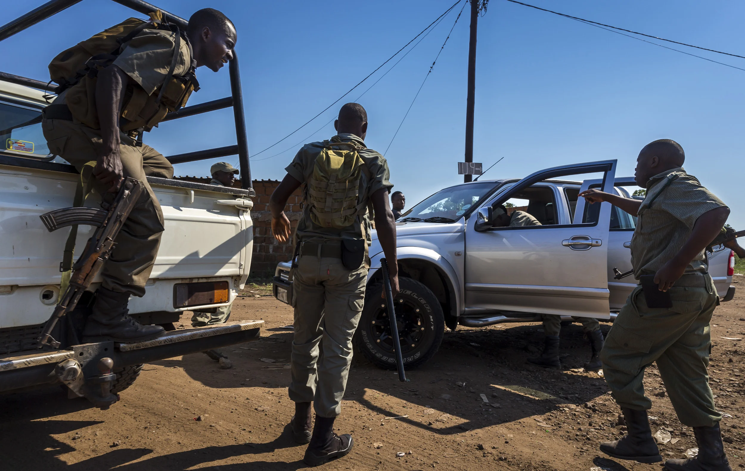 BAPTINE, MOZAMBIQUE, 1 APRIL 2016: A member of Sabie Game Park's IAPF contingent works with Mozabican Fauna Bravia units searching new and suspicious looking cars for evidence of Rhino poaching. Fauna Bravia are wildlife police in Mozambique. This is a very economically poor area and new cars are often considered a sign of money gained from rhino poaching. The police are treated with contempt by many of the local population, with one young man being arrested for saying, "fuck the police." Poaching is considered an important part of the local economy, with money from poachers often trickling into the local economy in this depressed area. (Photo by Brent Stirton/Getty Images Reportage for National Geographic Magazine.)